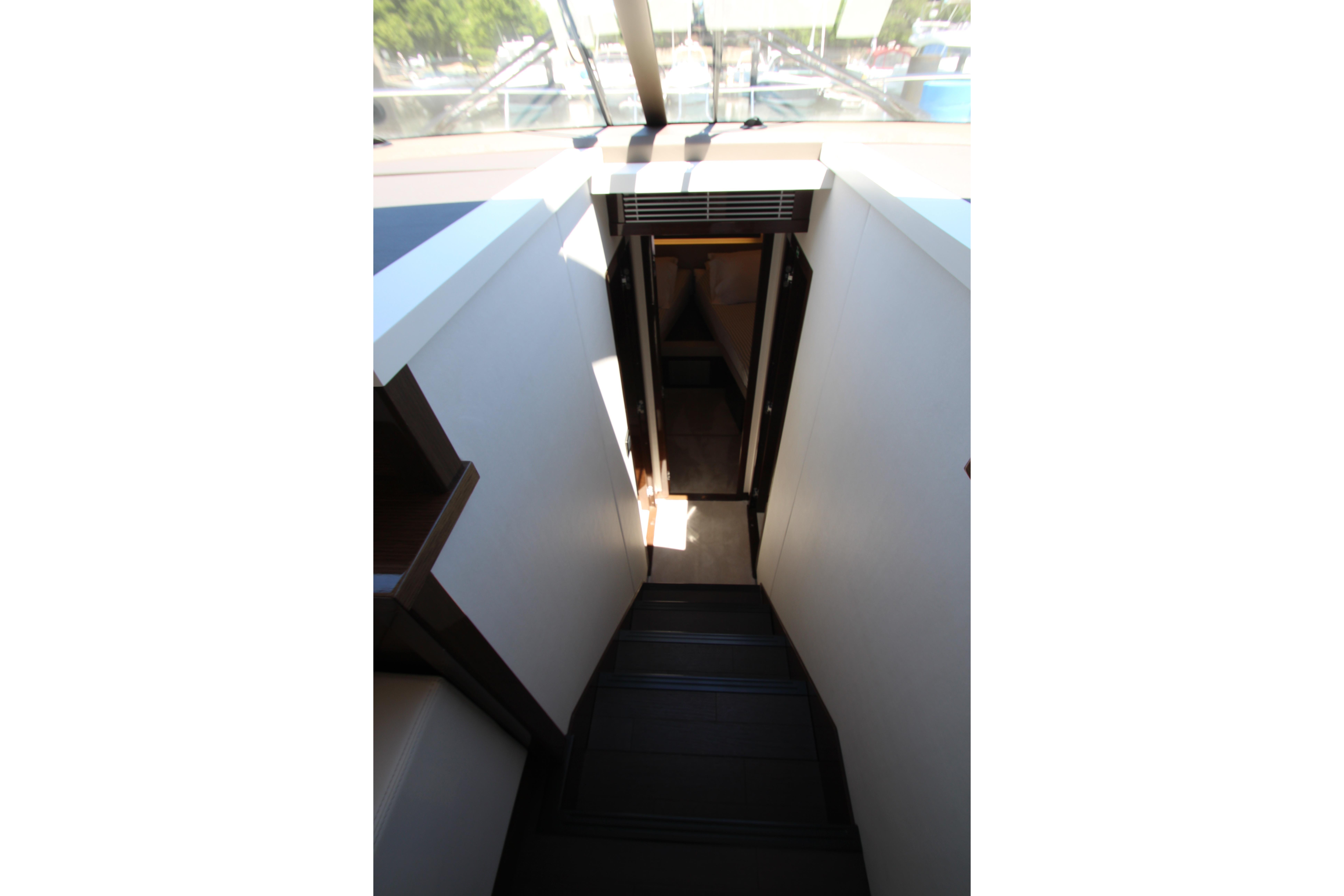 Staircase leading to lower deck on 2022 Prestige 520 yacht interior.