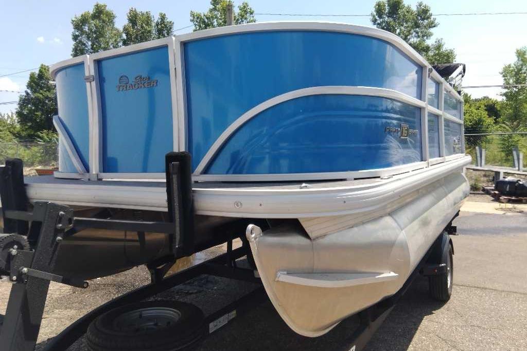 2026 Sun Tracker Party Barge 16 DLX pontoon boat on trailer, blue exterior.