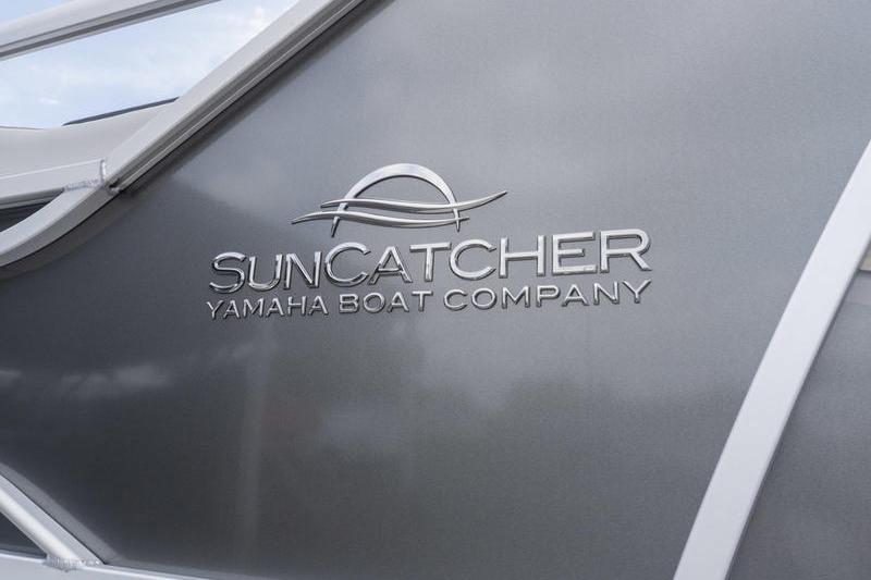SunCatcher Elite 326 SS 2026 boat logo on sleek gray surface.