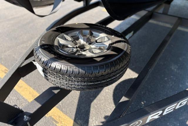Spare tire on a 2025 Regency 250 DL3 trailer in a parking lot.