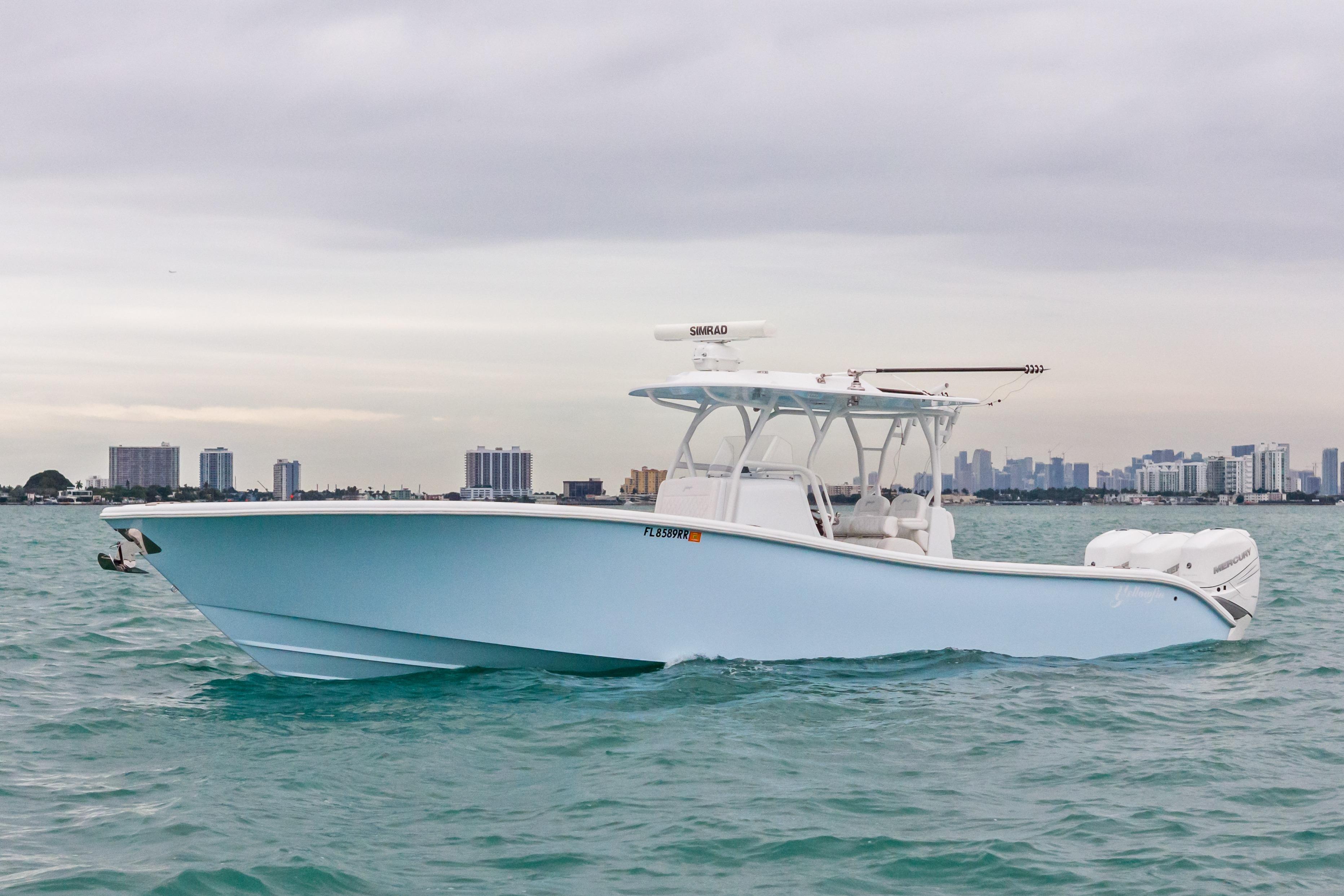 2021 Yellowfin 36 Offshore boat cruising on water with city skyline in background.