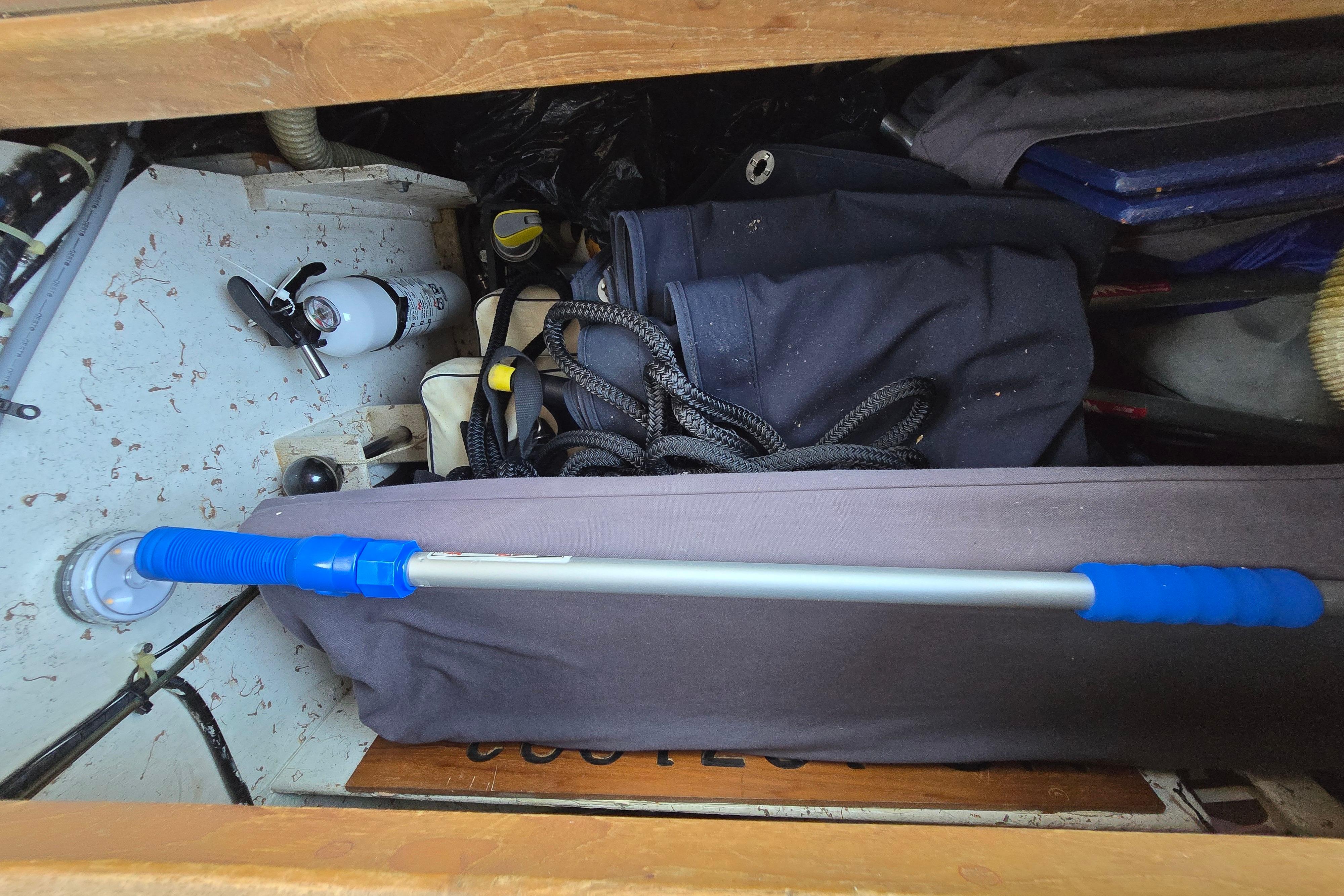 Storage compartment on a 1993 Caliber 35 boat, featuring ropes and equipment.
