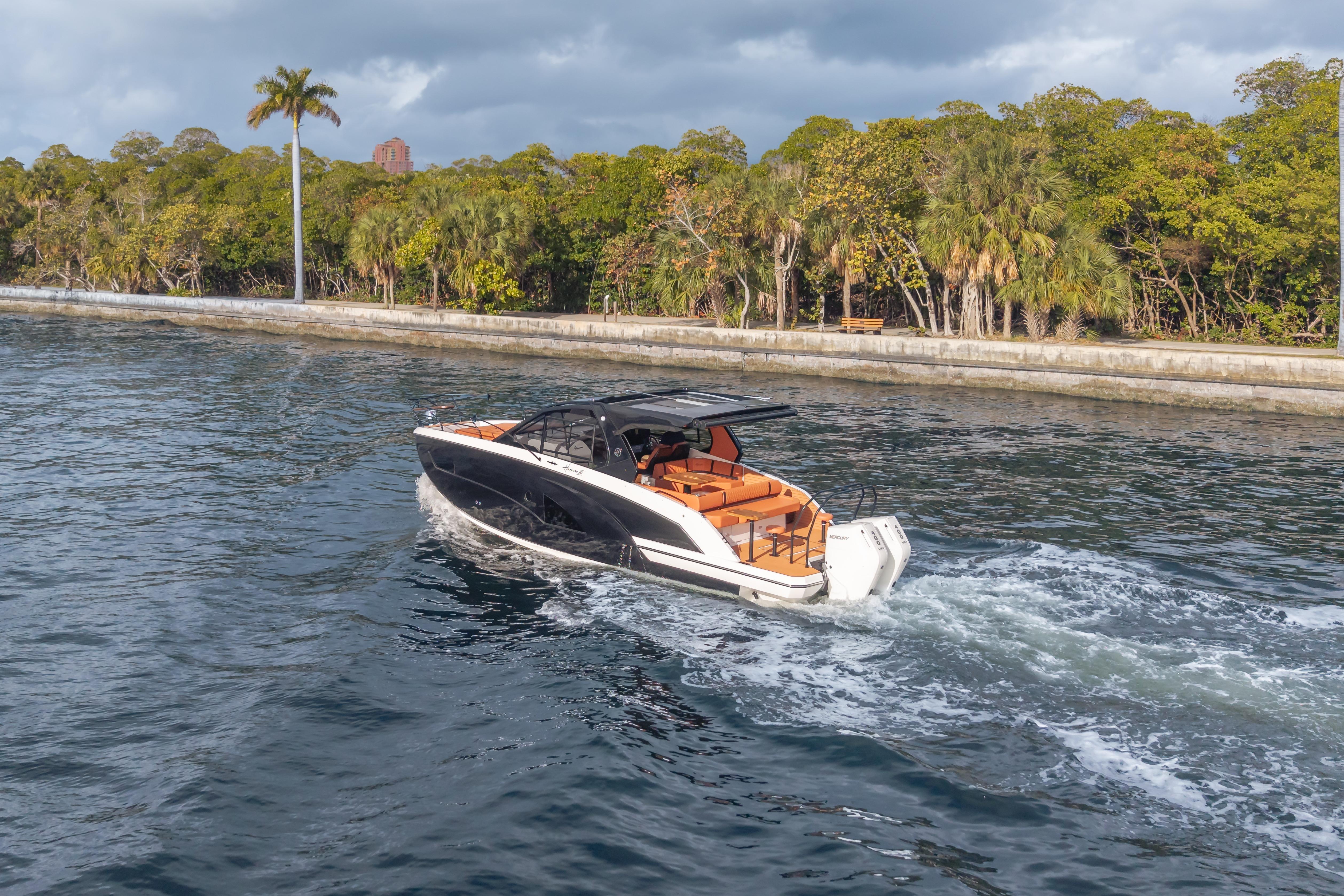 Luxury Hanover 387 boat cruising near lush shoreline, 2026 model.