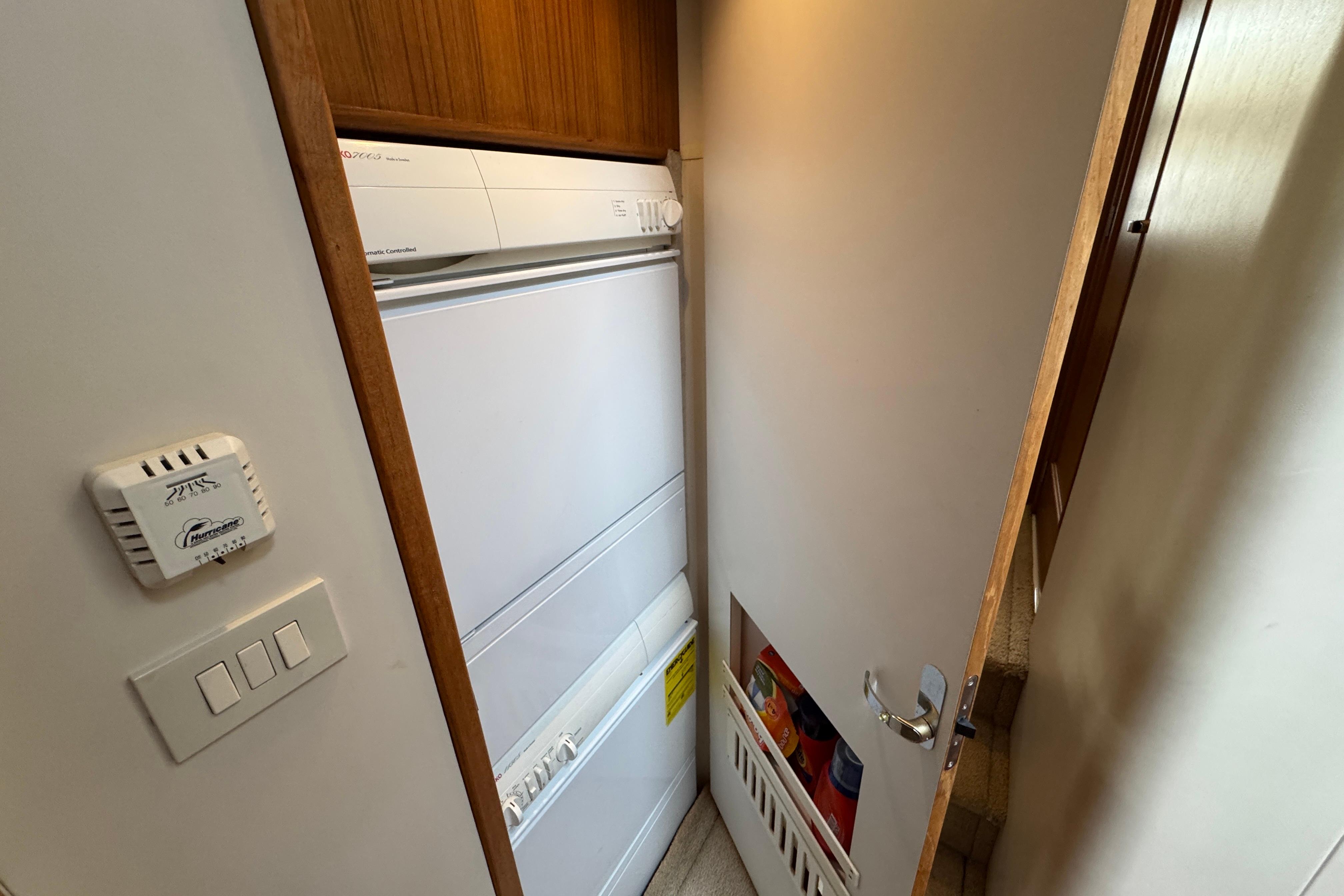 Laundry area inside 1998 Bayliner 5788 Pilot House Motoryacht, featuring a compact washer and dryer.