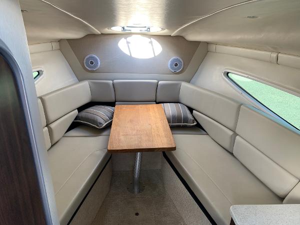 Interior of a 2017 Regal 26 Express with U-shaped seating and a wooden table.