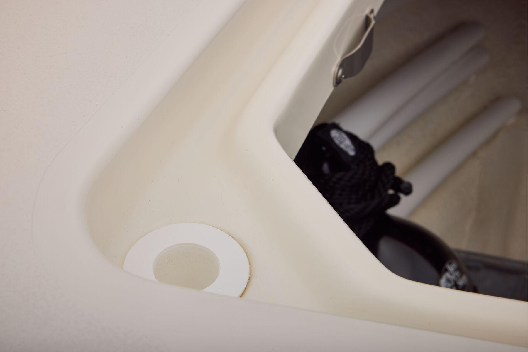 Storage compartment in 2026 Mako 24 APEX boat with ropes and accessories.