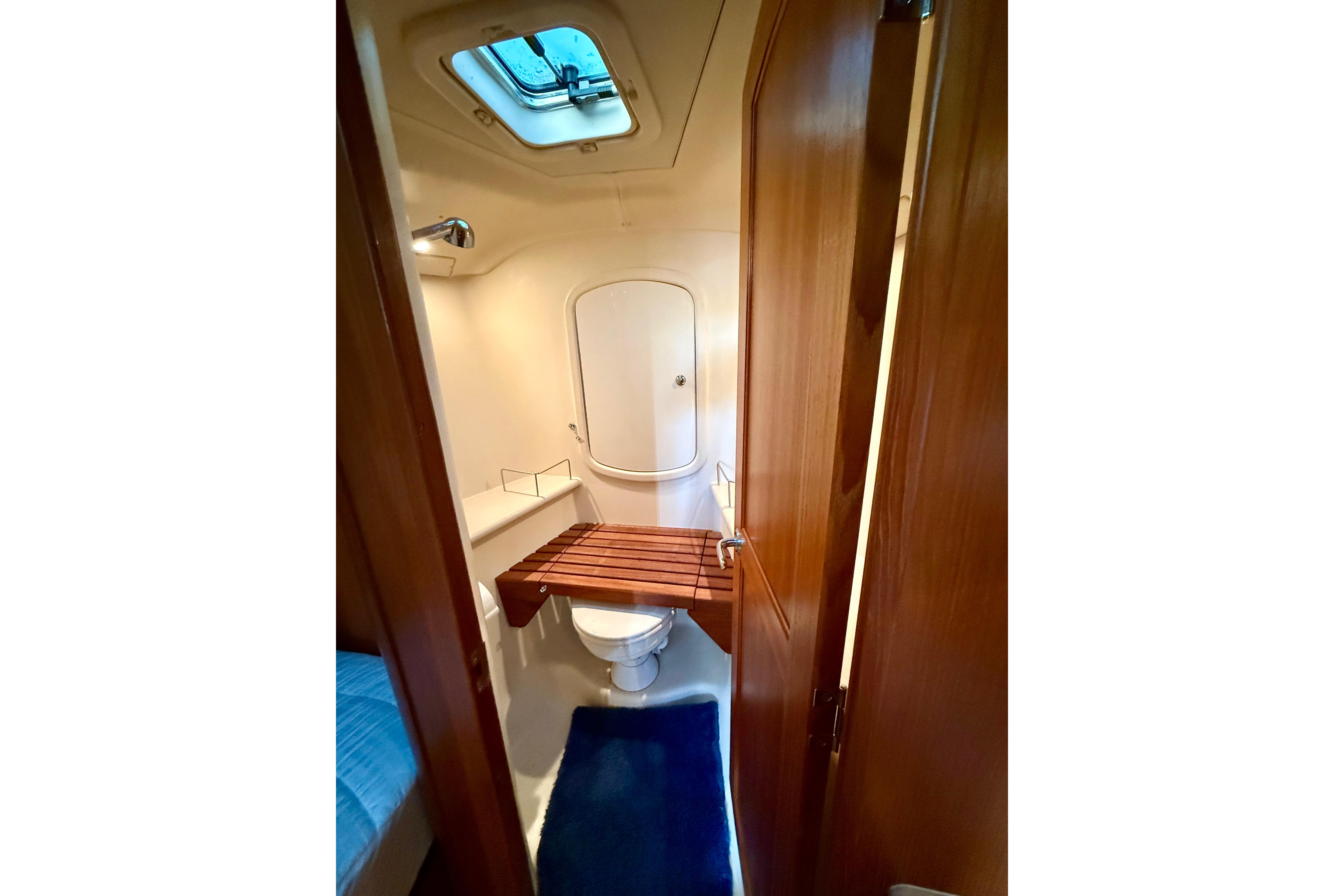 Bathroom interior of 2007 Hunter 41 Deck Salon yacht, featuring wooden accents and skylight.