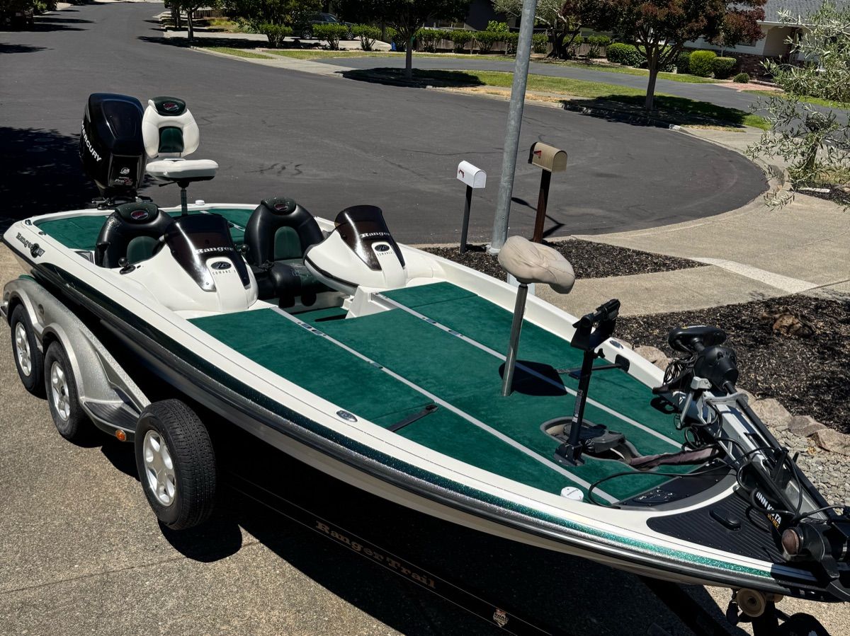 2005 Ranger Z-21 bass boat with green carpet, parked on a trailer in a residential area.