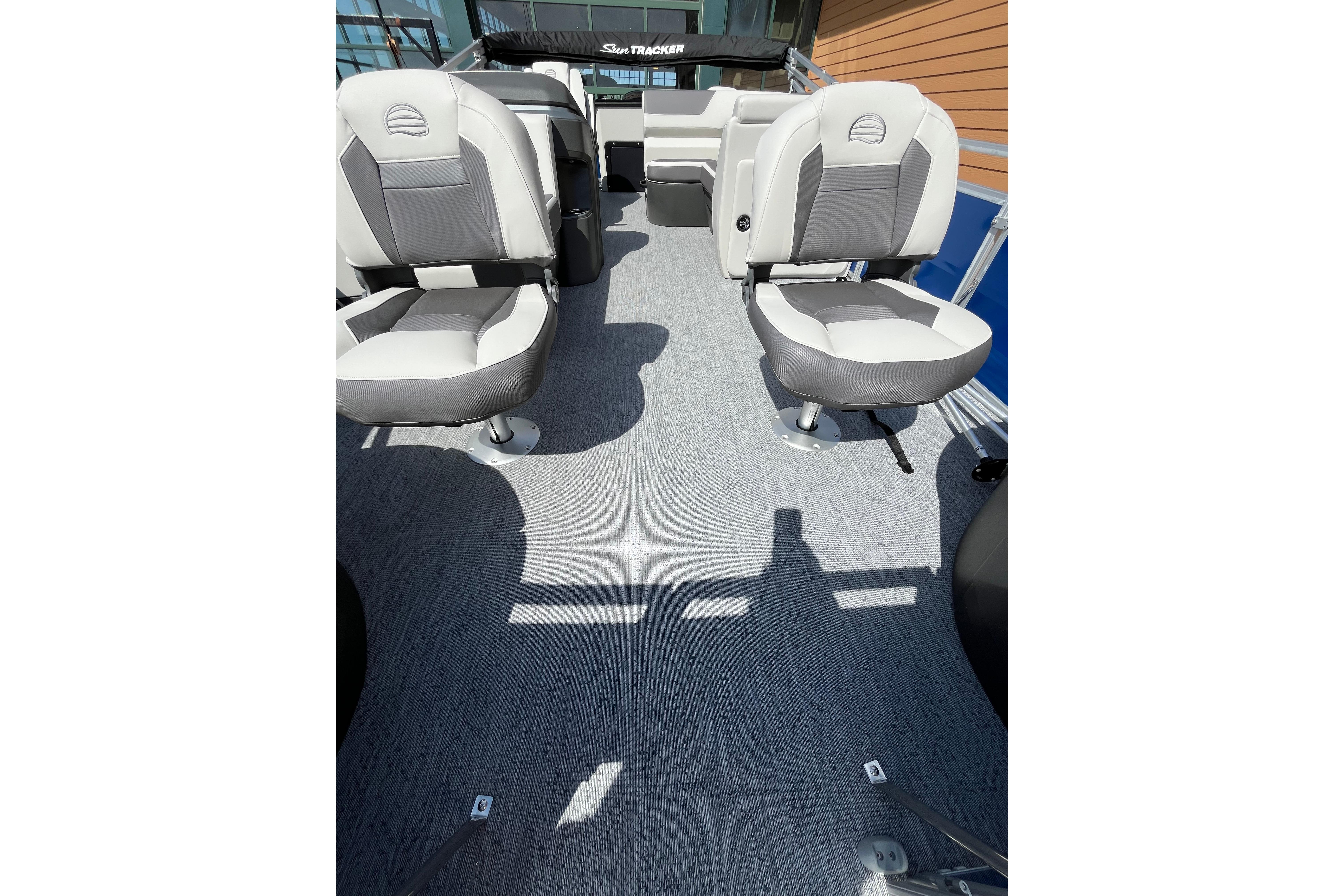 2026 Sun Tracker Fishin' Barge 20 DLX interior with gray seating and carpeted floor.