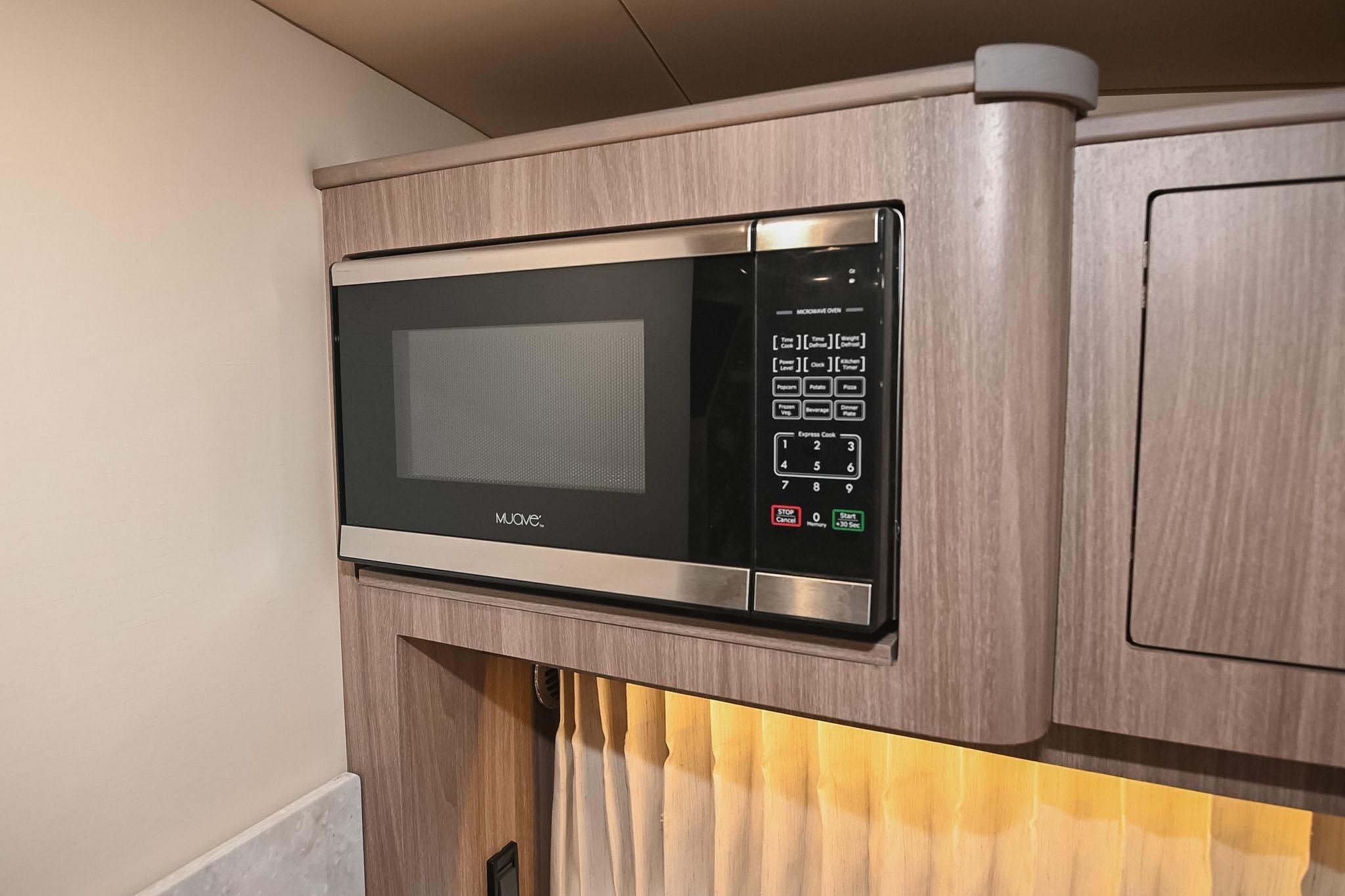 Microwave in 2021 Regal 33 Express boat interior, featuring modern wood cabinetry.