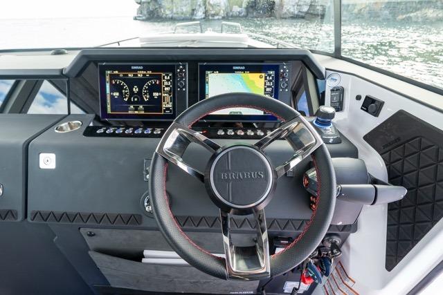 Steering wheel and dashboard of 2026 Axopar 37 XC Cross Cabin boat, featuring advanced navigation displays.