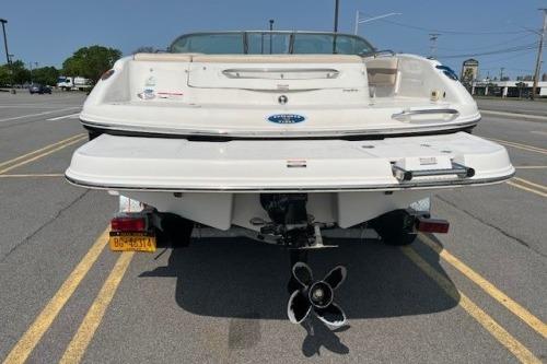 2006 Chaparral 220 SSi boat rear view in parking lot, showcasing propeller and swim platform.