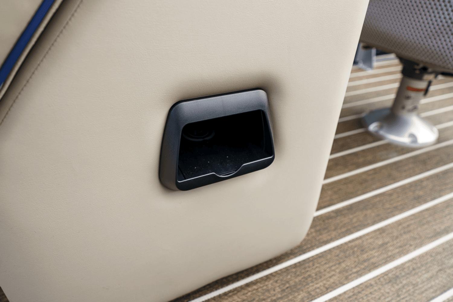 Cup holder on 2023 Premier 230 Solaris boat with beige upholstery and striped flooring.