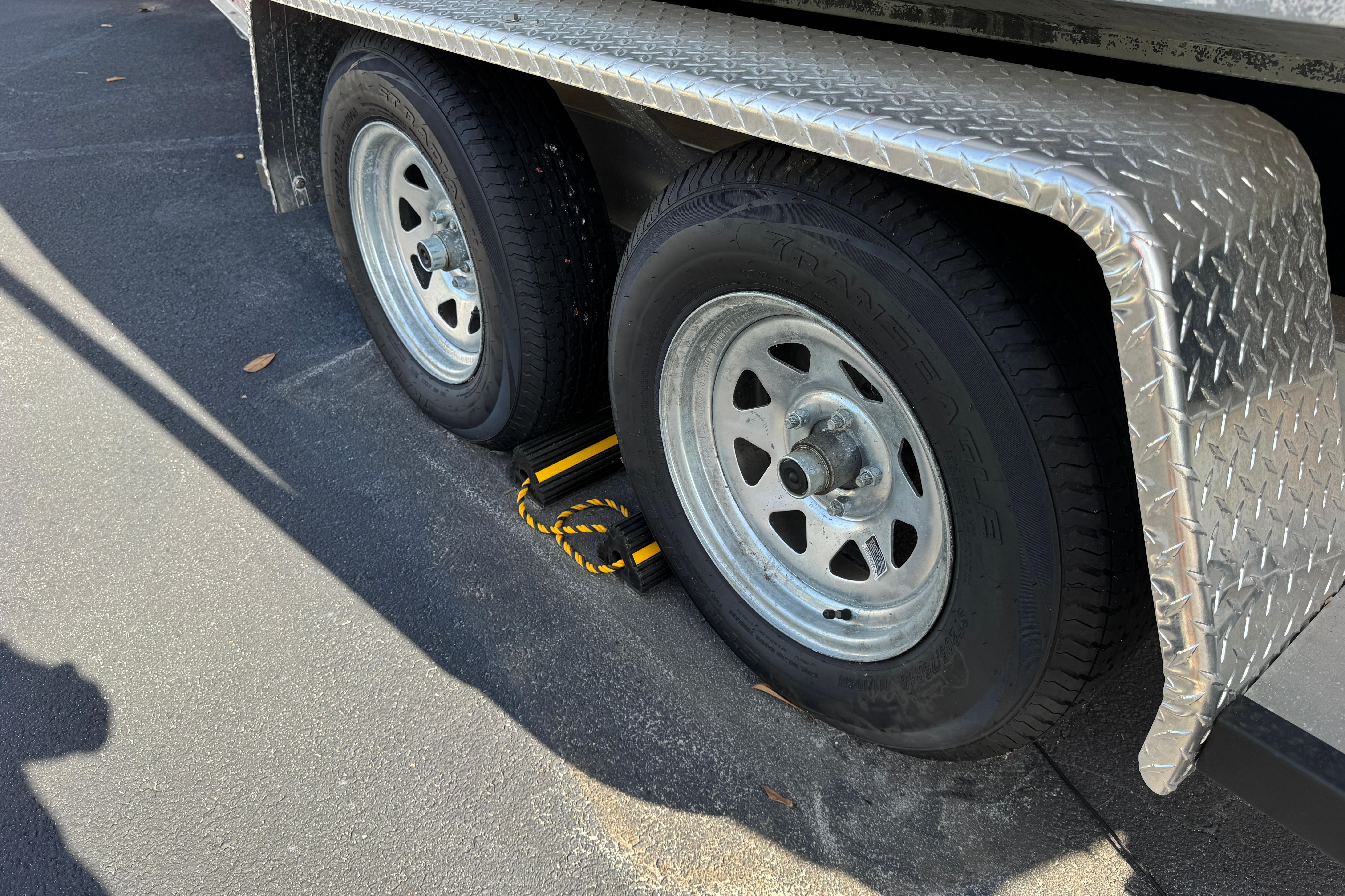 Trailer wheels with chocks on a 2018 Hurricane SunDeck 2400 OB boat trailer.