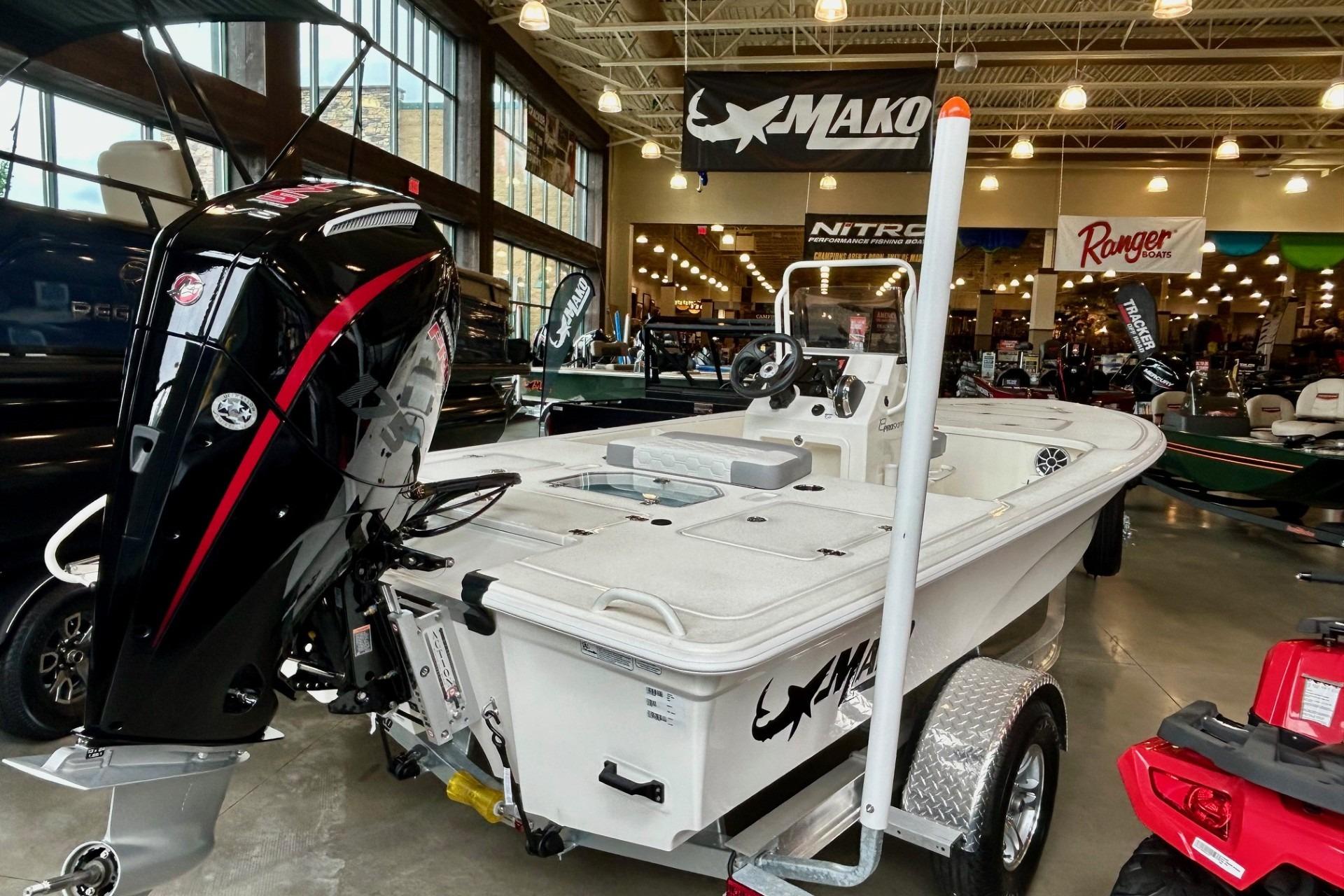 2026 Mako Pro Skiff 18 boat displayed indoors with powerful outboard motor.