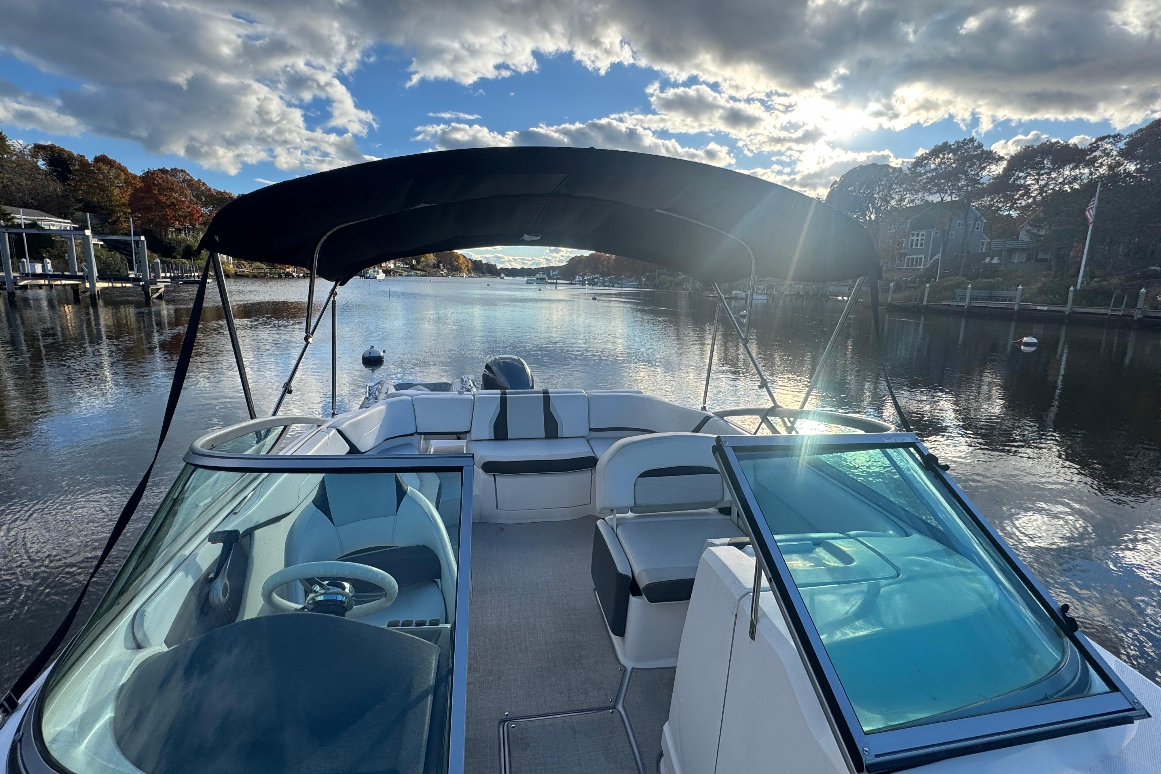 2017 Regal 23 OBX boat on a serene river under a cloudy sky.