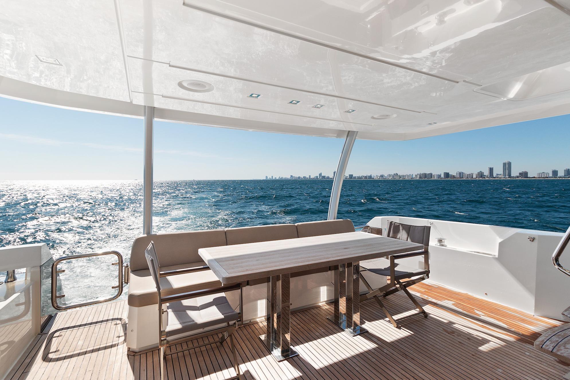 Luxurious 2015 Prestige 750 yacht deck with ocean view and city skyline.