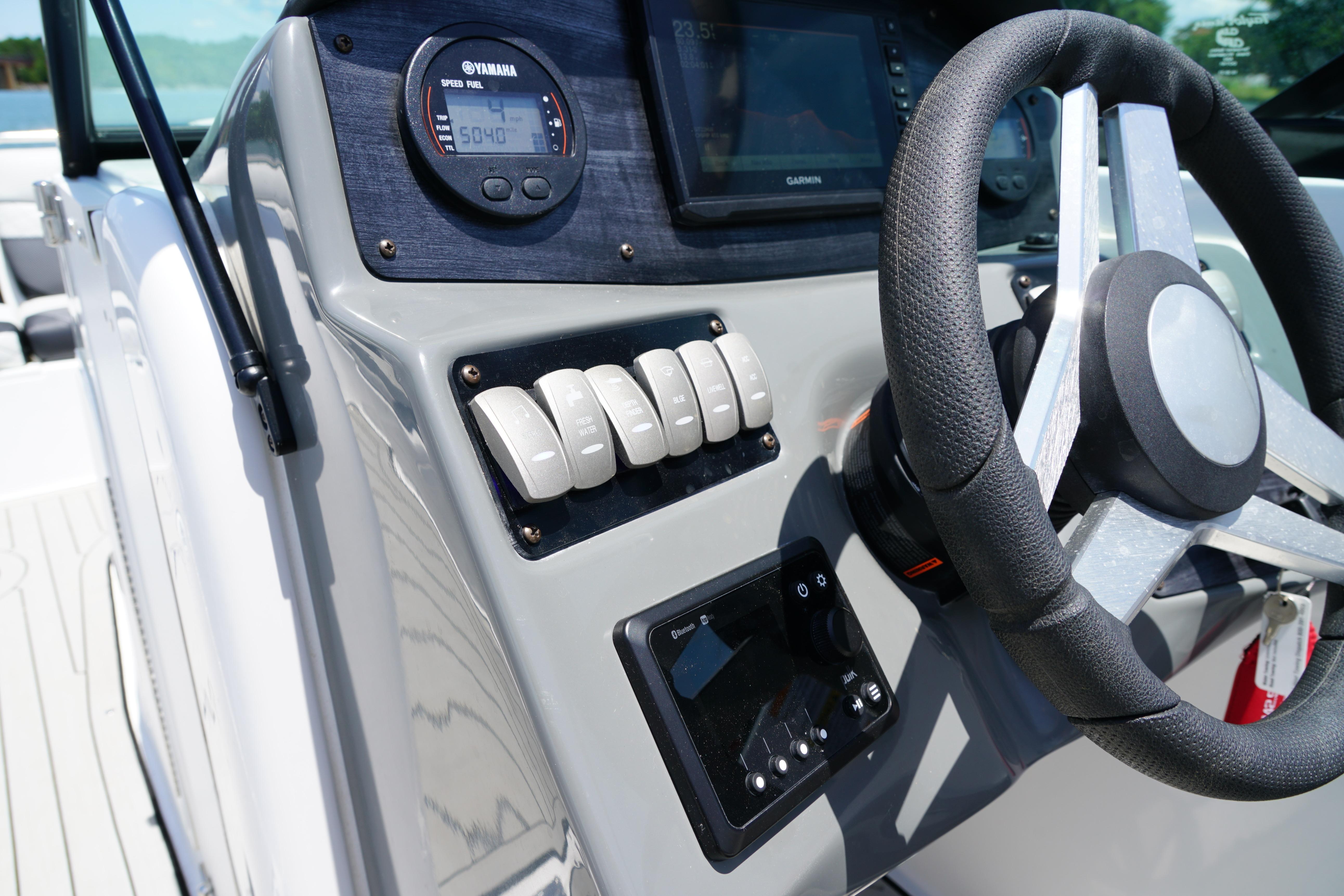 Dashboard of a 2020 Hurricane SunDeck 2486 OB boat with steering wheel and controls.