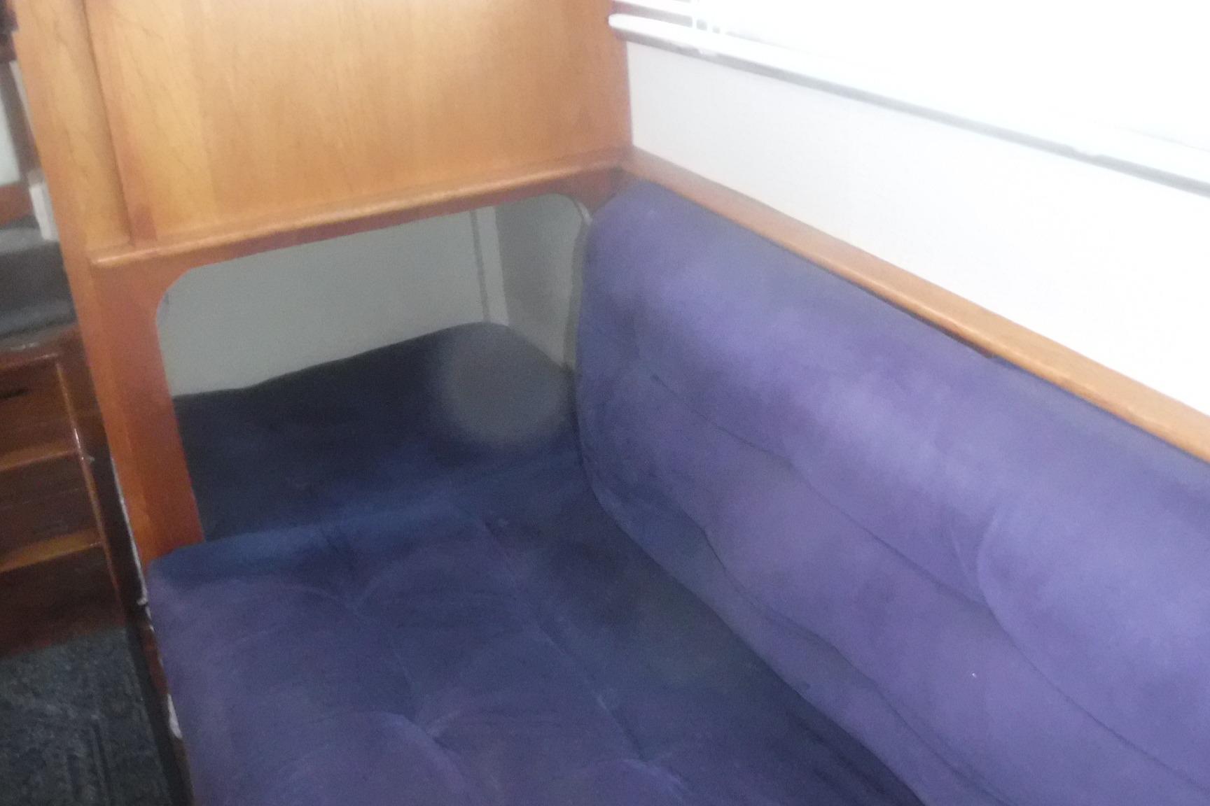 Interior seating of 1983 Grand Banks 36 Classic with blue upholstery and wooden accents.