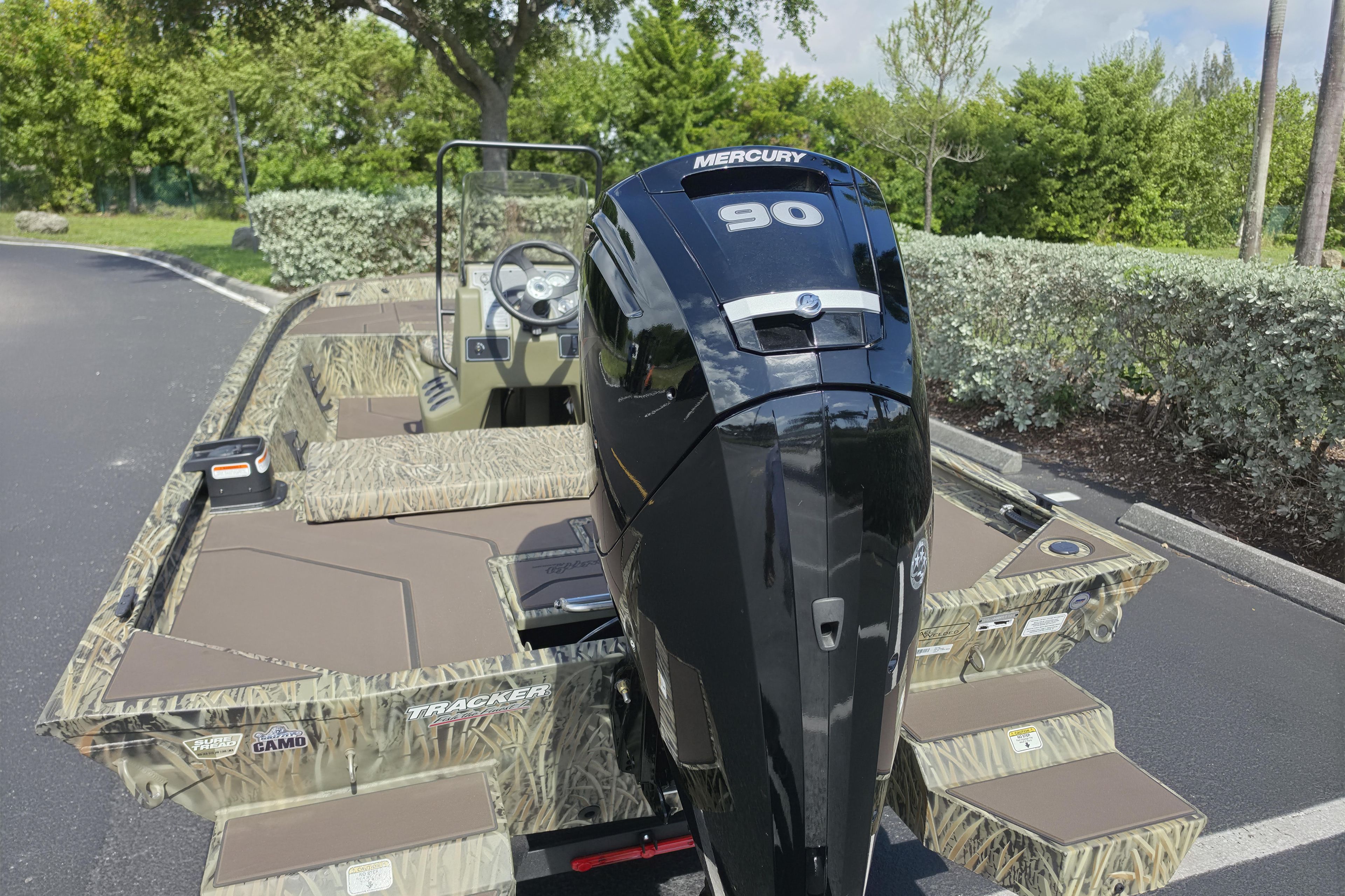 2026 Tracker Grizzly 1860 CC boat with Mercury 90 engine, parked outdoors.