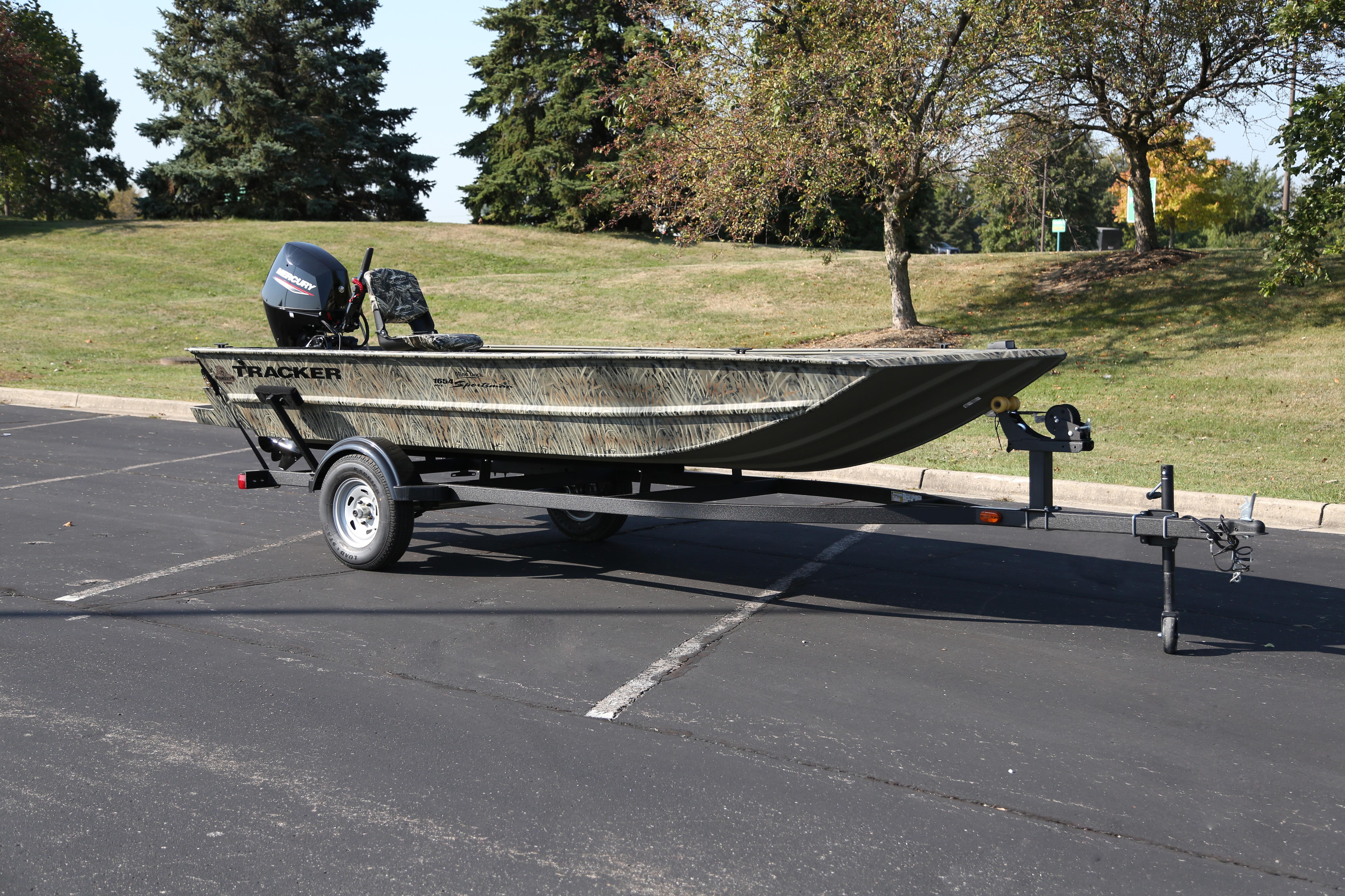 2026 Tracker Grizzly 1654 T Sportsman boat on trailer in parking lot.
