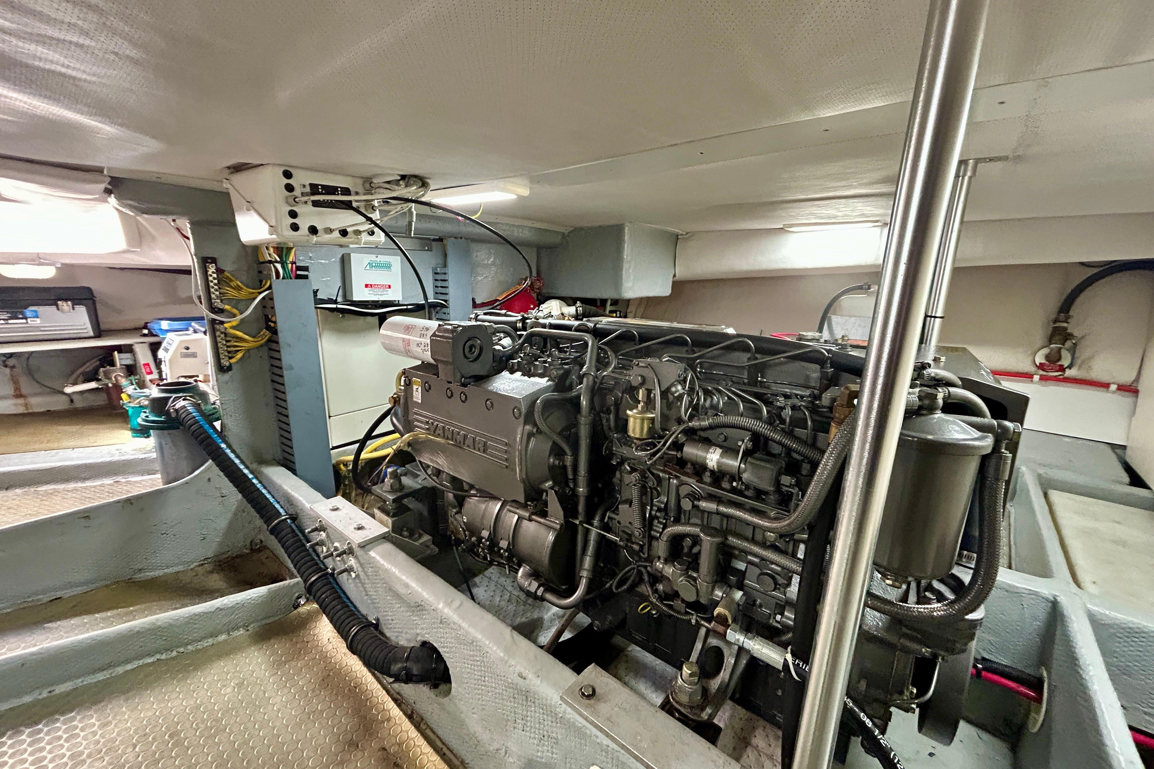 Engine room of a 2006 Mainship 34 Trawler, showcasing detailed machinery and components.
