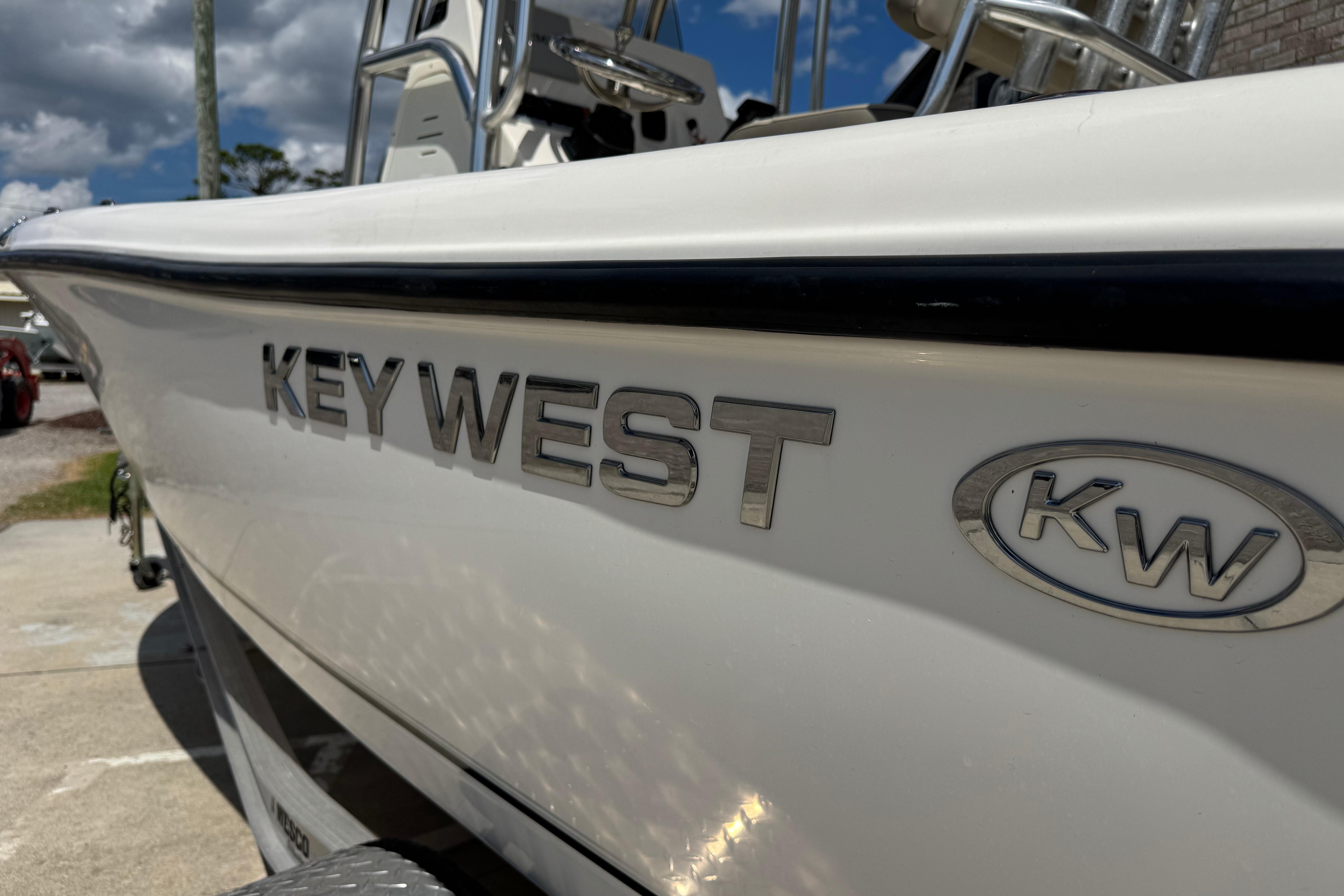 2022 Key West 189 FS boat, close-up of logo and sleek design under a blue sky.