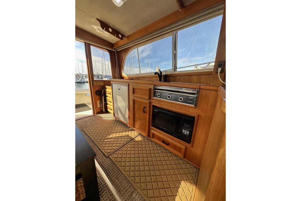 1985 Egg Harbor 33 Sedan interior with wooden cabinetry and kitchen appliances.
