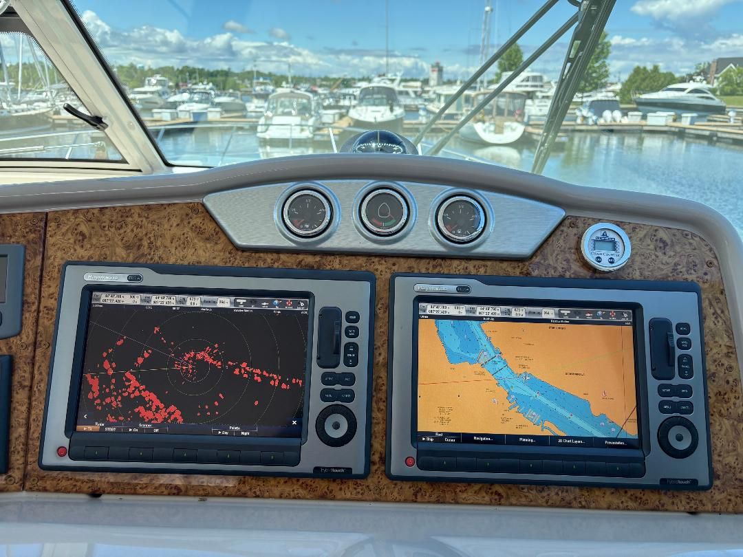 The dashboard of a 2011 Formula 45 with two navigation screens and a marina in the background.