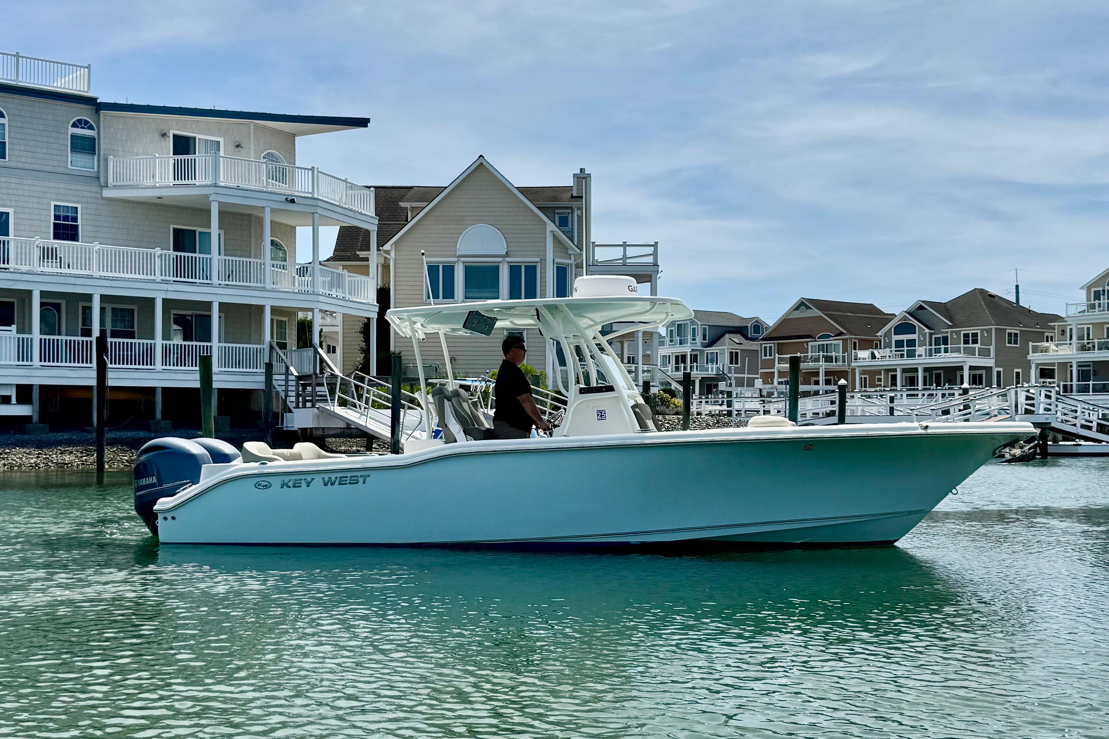 2022 Key West 263 FS boat cruising near waterfront homes.