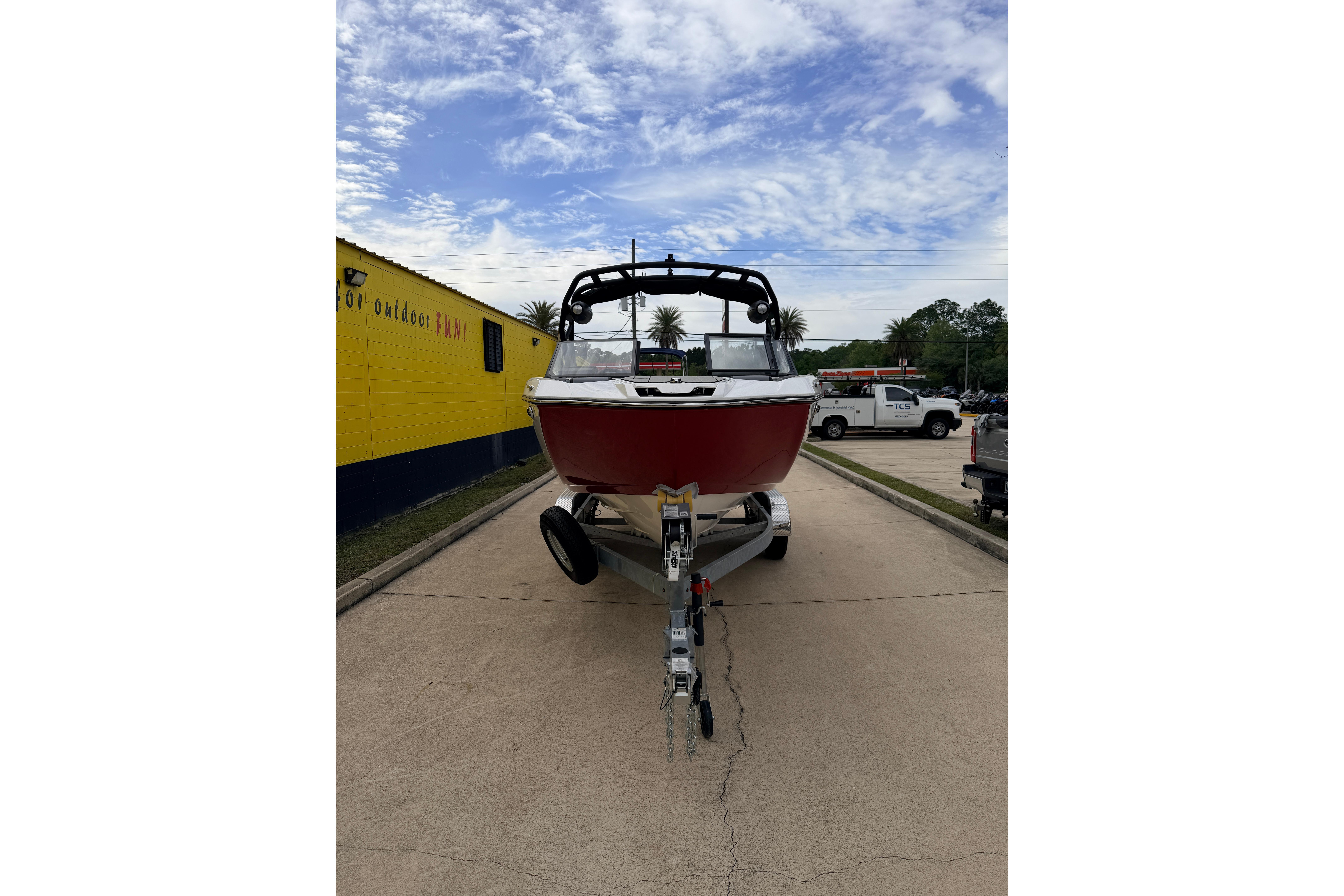 Yamaha Boats 222XD 2026 on trailer, red design, blue sky.