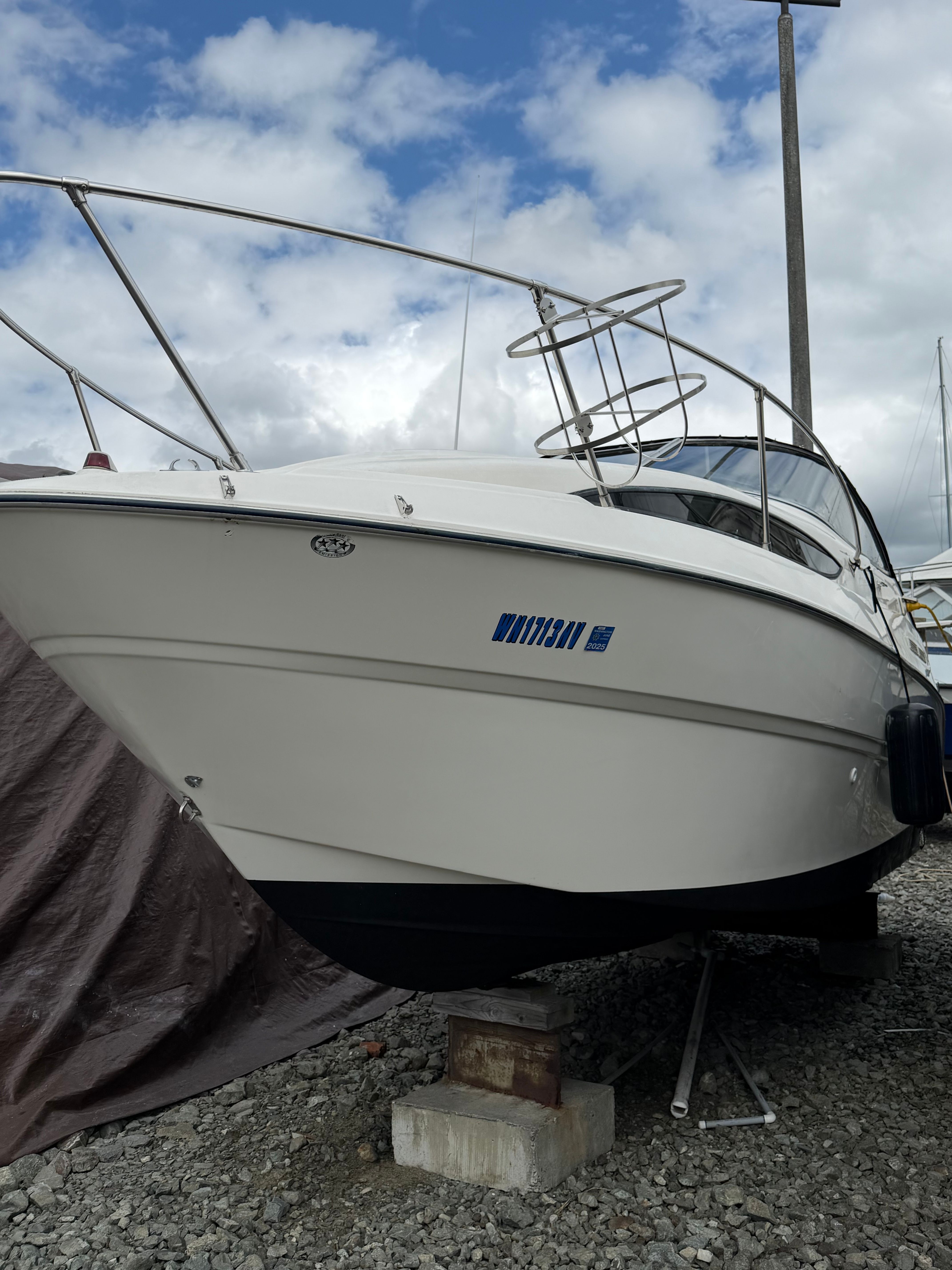 2005 Bayliner Cierra 245 boat on gravel surface.