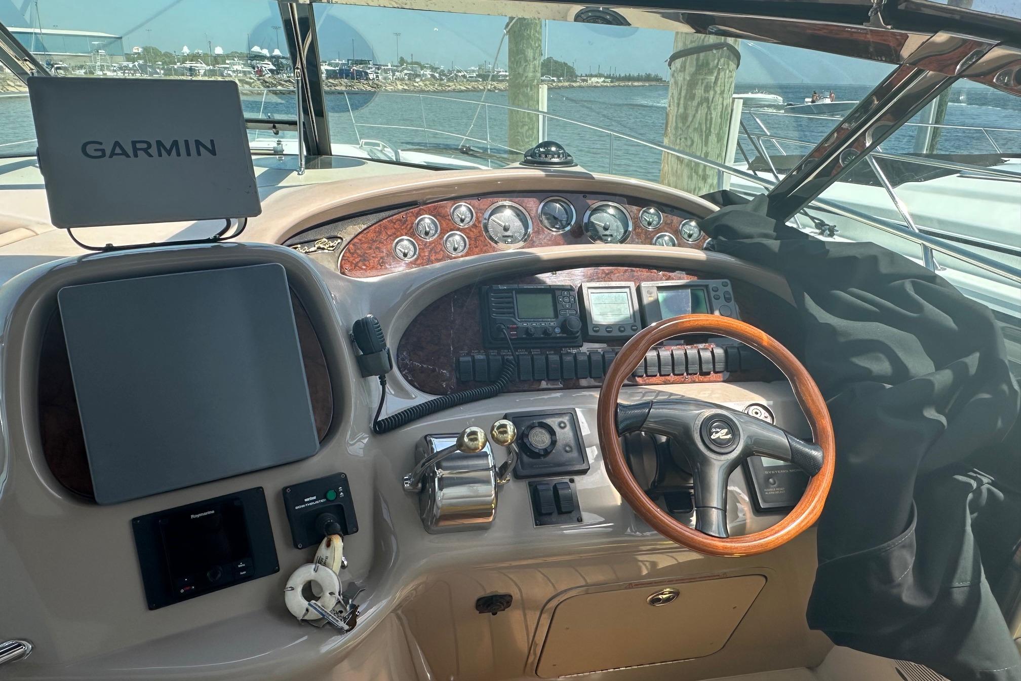 Cockpit of 2001 Sea Ray 410 Sundancer with Garmin navigation system and wooden steering wheel.