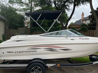 A 2004 Chaparral 190 SSi boat on a trailer in a backyard setting.