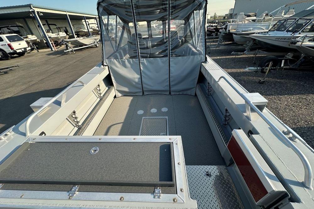 2025 Hewescraft 210 Sea Runner ET boat interior with canopy, parked in a marina.