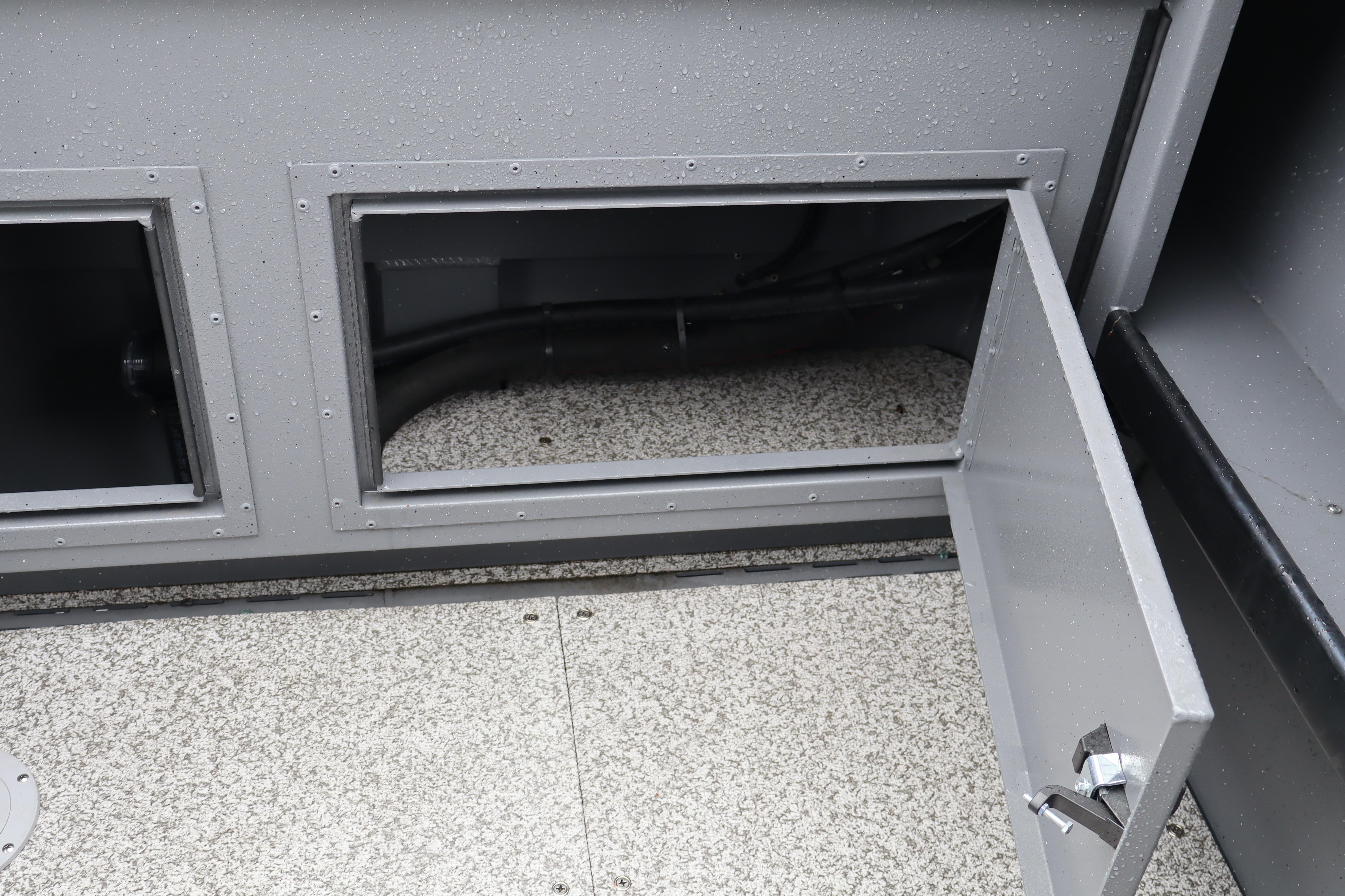 Open storage compartment on 2026 Alumaweld Horizon 24 boat, showcasing interior details.