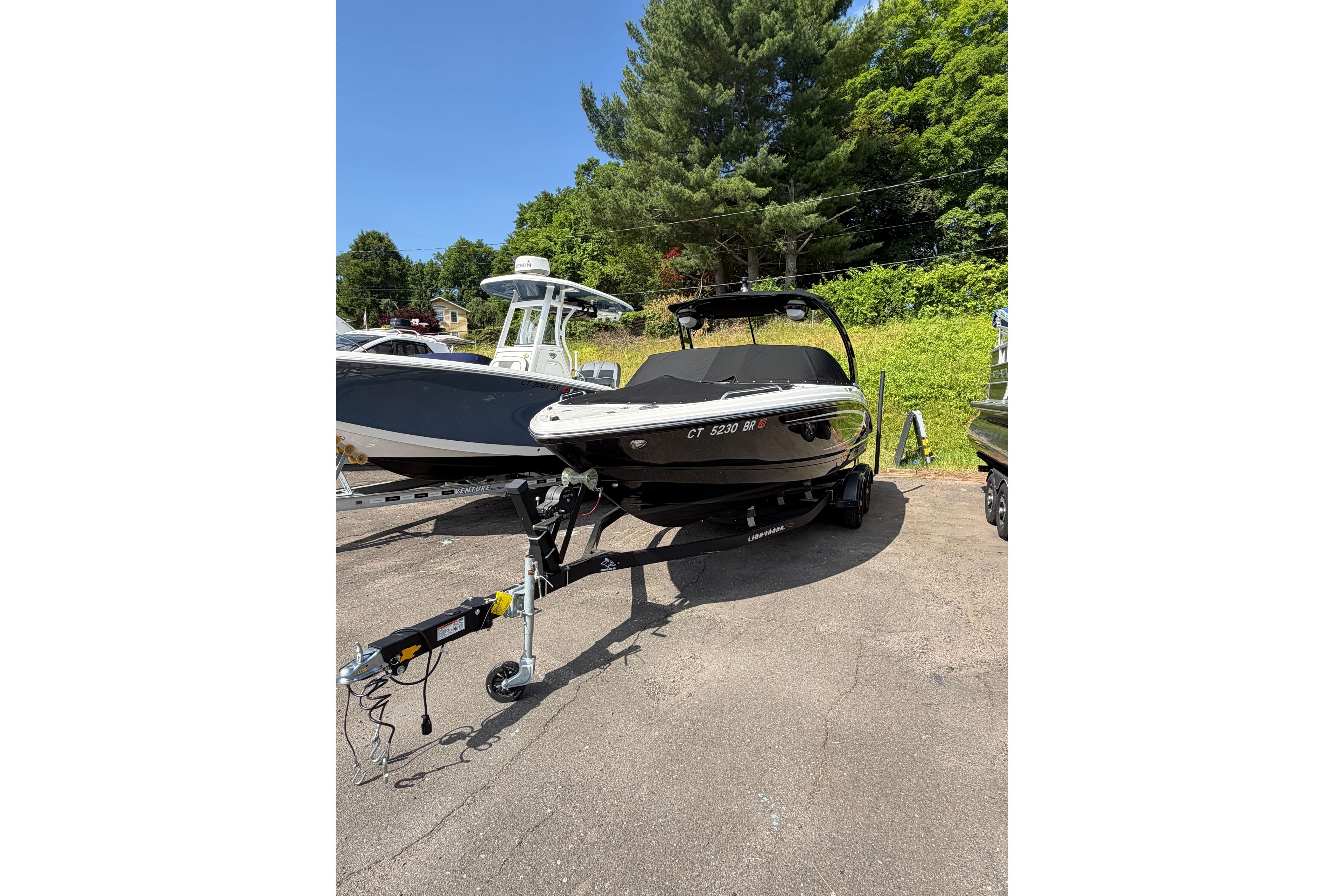 2025 Chaparral 230 SSi boat on trailer, parked outdoors on a sunny day.
