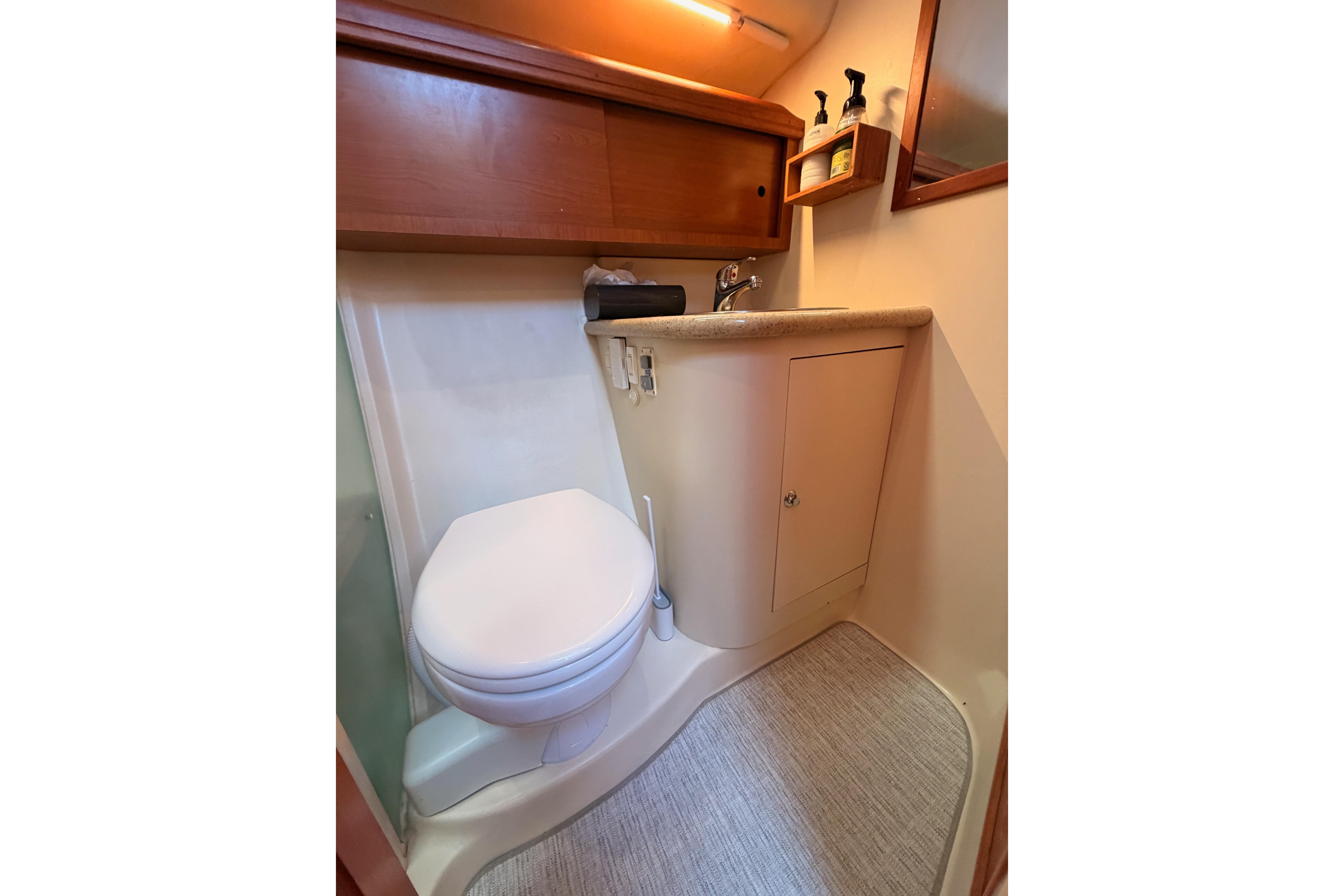 2008 Hunter 45 Deck Salon bathroom with toilet, sink, and storage cabinet.