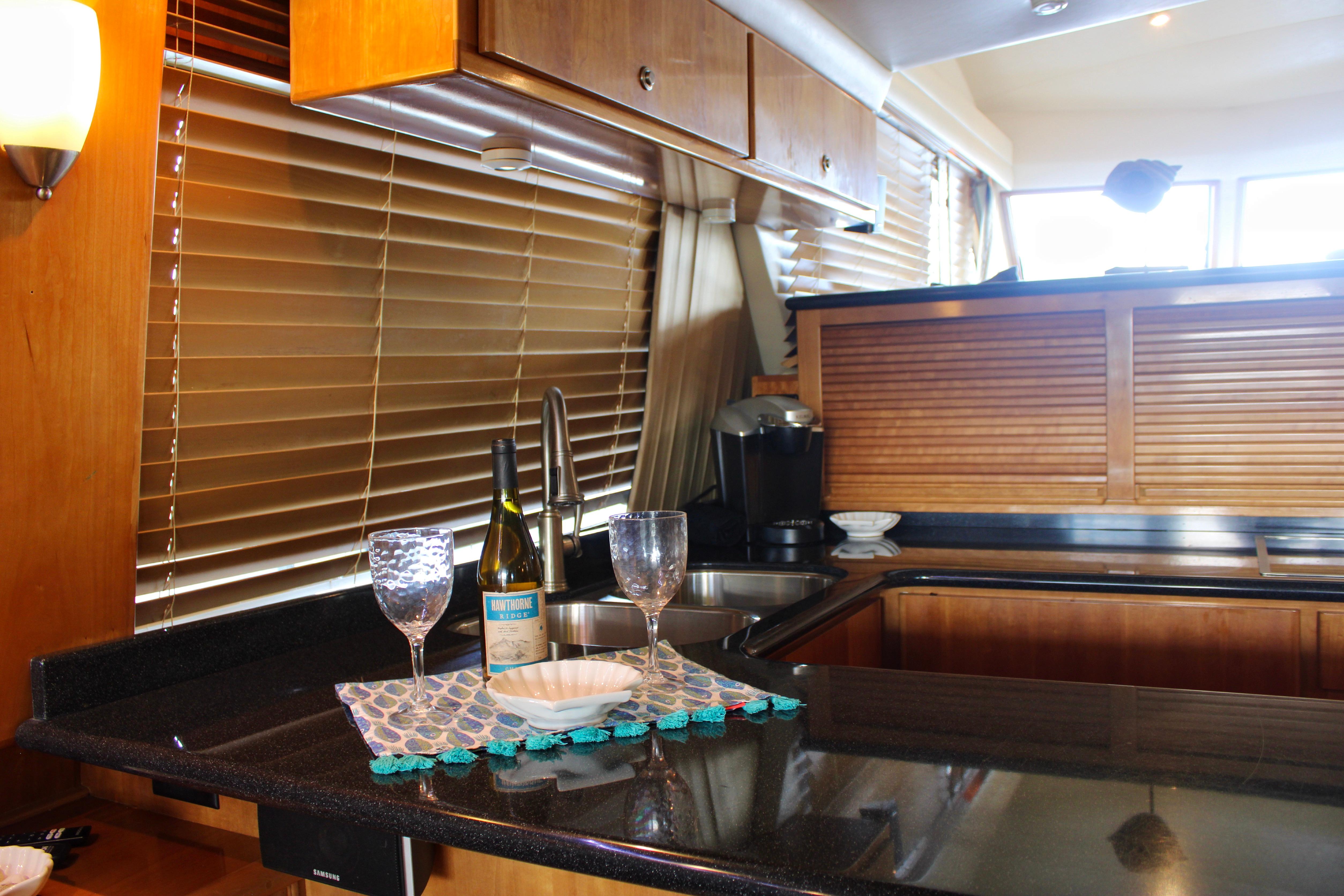 Luxurious 2007 Navigator 5100 yacht kitchen with wine glasses and bottle on counter.