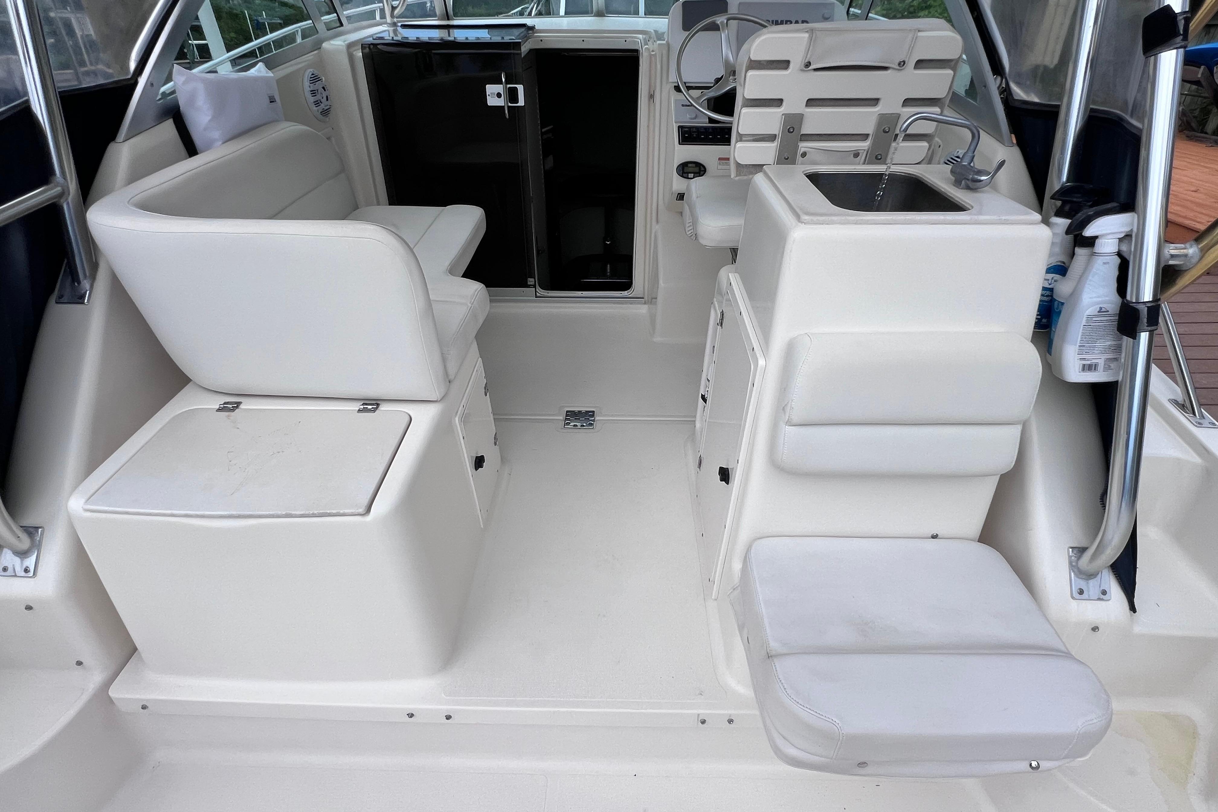 2005 Pursuit 3070 Offshore boat interior with seating, sink, and helm station.