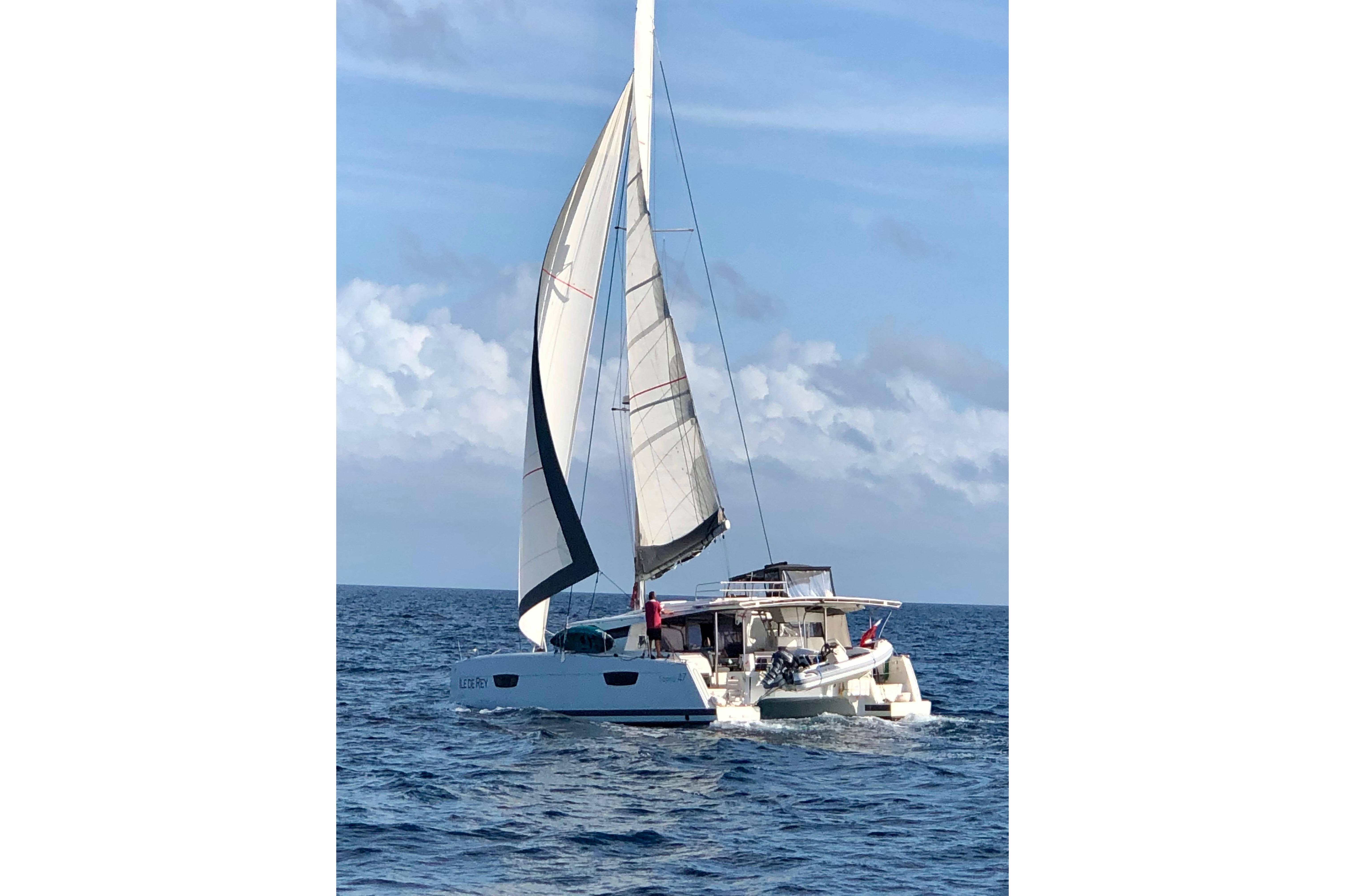 2020 Fountaine Pajot Saona 47 sailing catamaran on open sea under clear skies.