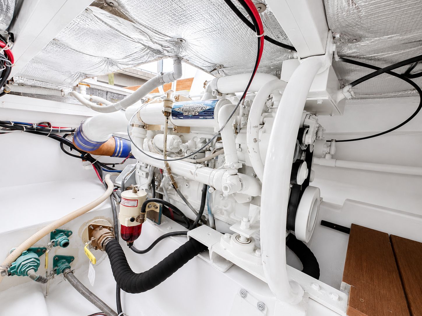 The engine room of a 1992 L&H 33 boat shows a well-maintained engine and wiring.