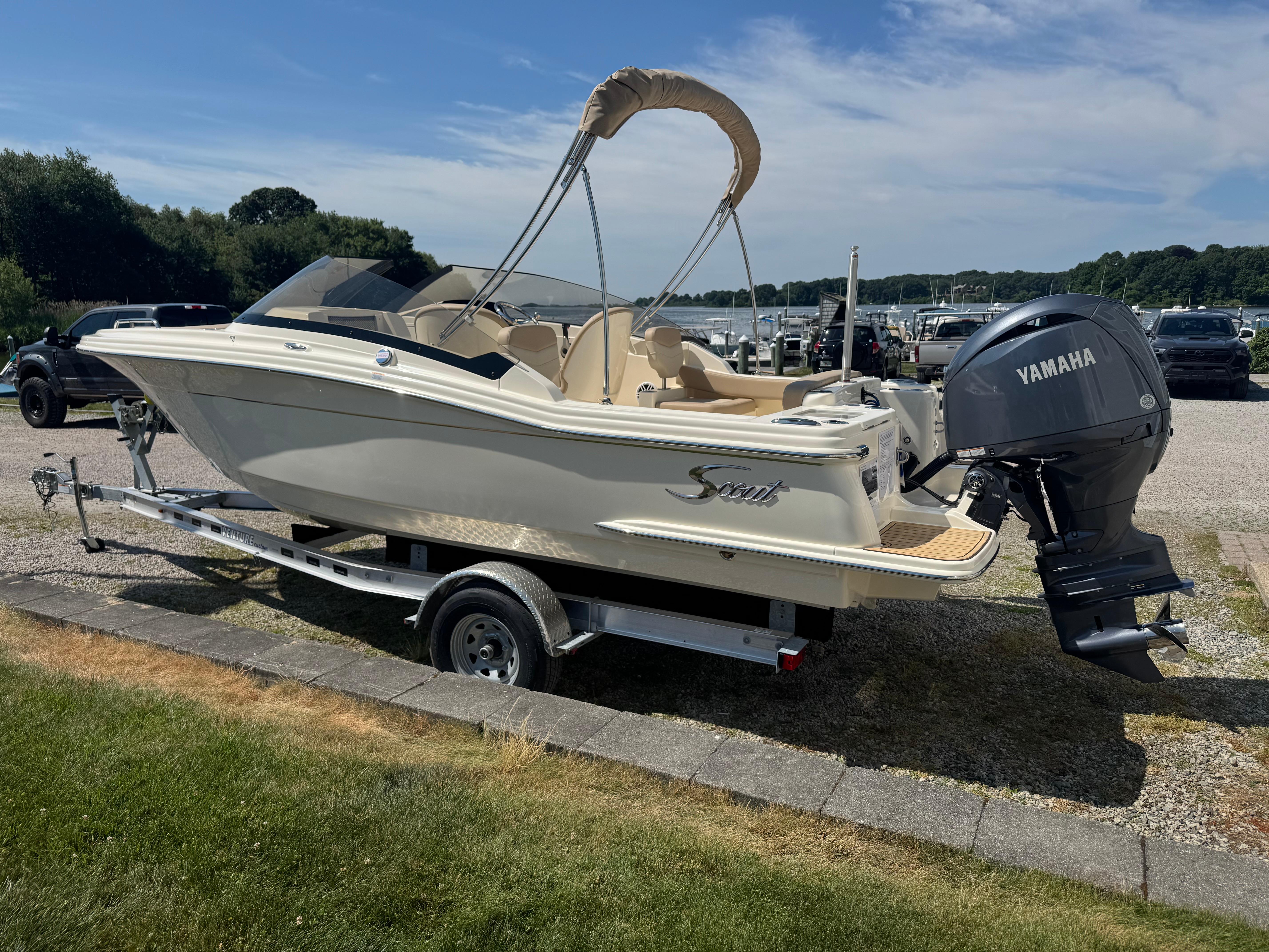 2025 Scout 215 Dorado boat on trailer with Yamaha outboard motor, parked outdoors.