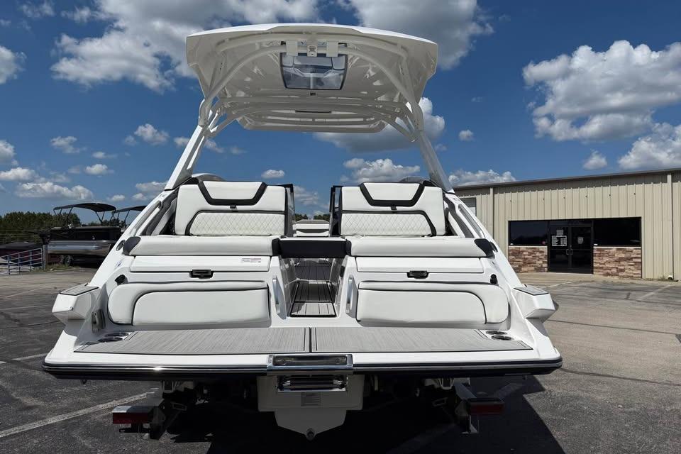 2026 Yamaha Boats 275SD, rear view, showcasing sleek design and spacious seating under a clear sky.