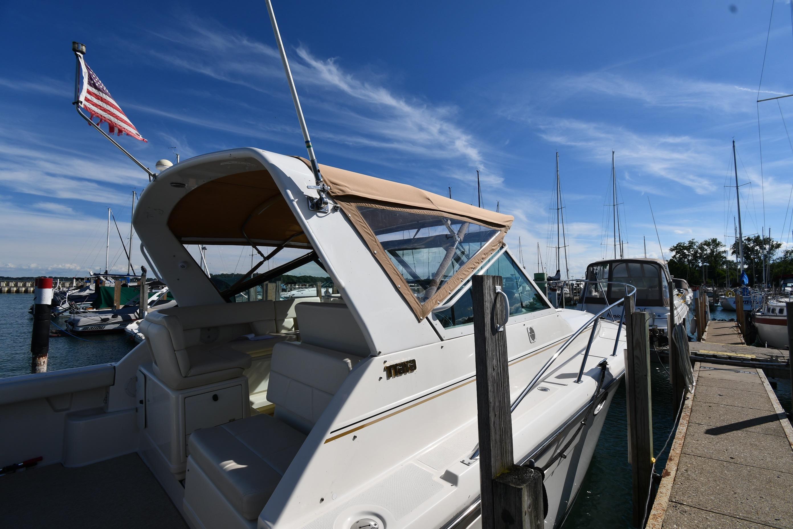 1998 Tiara Yachts 3100 Open docked at marina under clear blue sky.