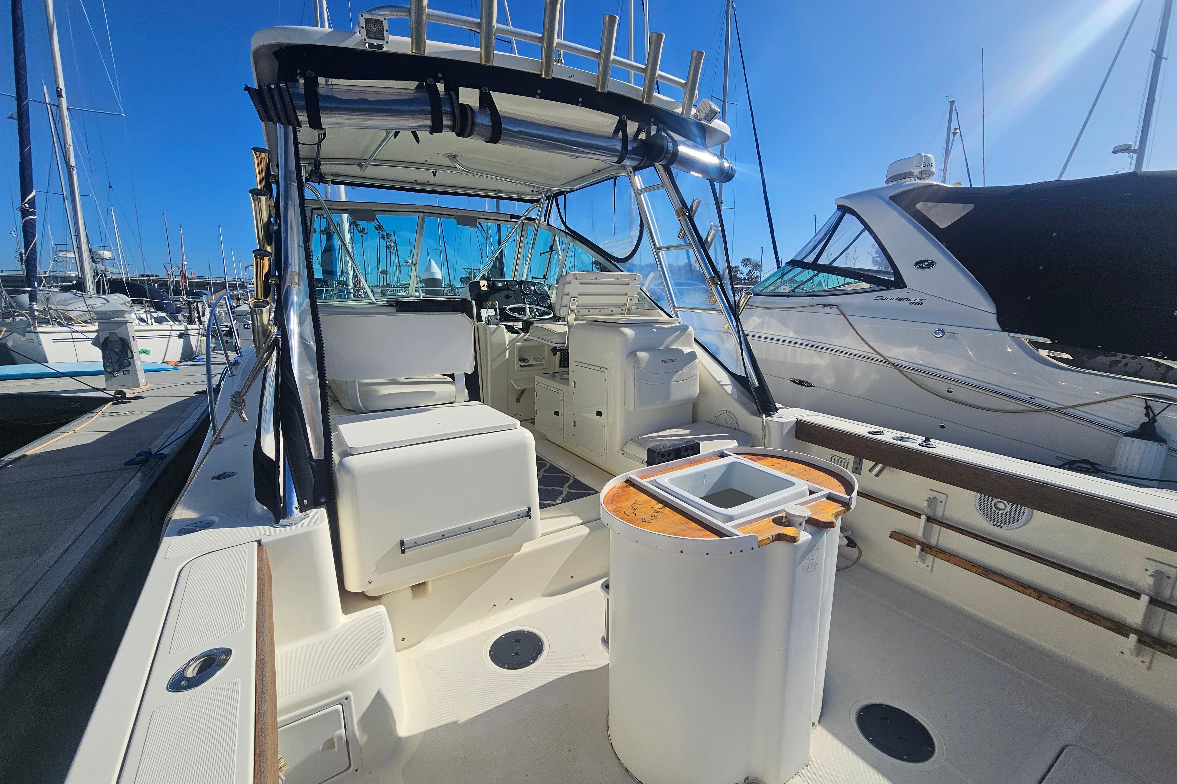 2001 Pursuit 3000 Express boat docked at marina, featuring spacious cockpit and helm.