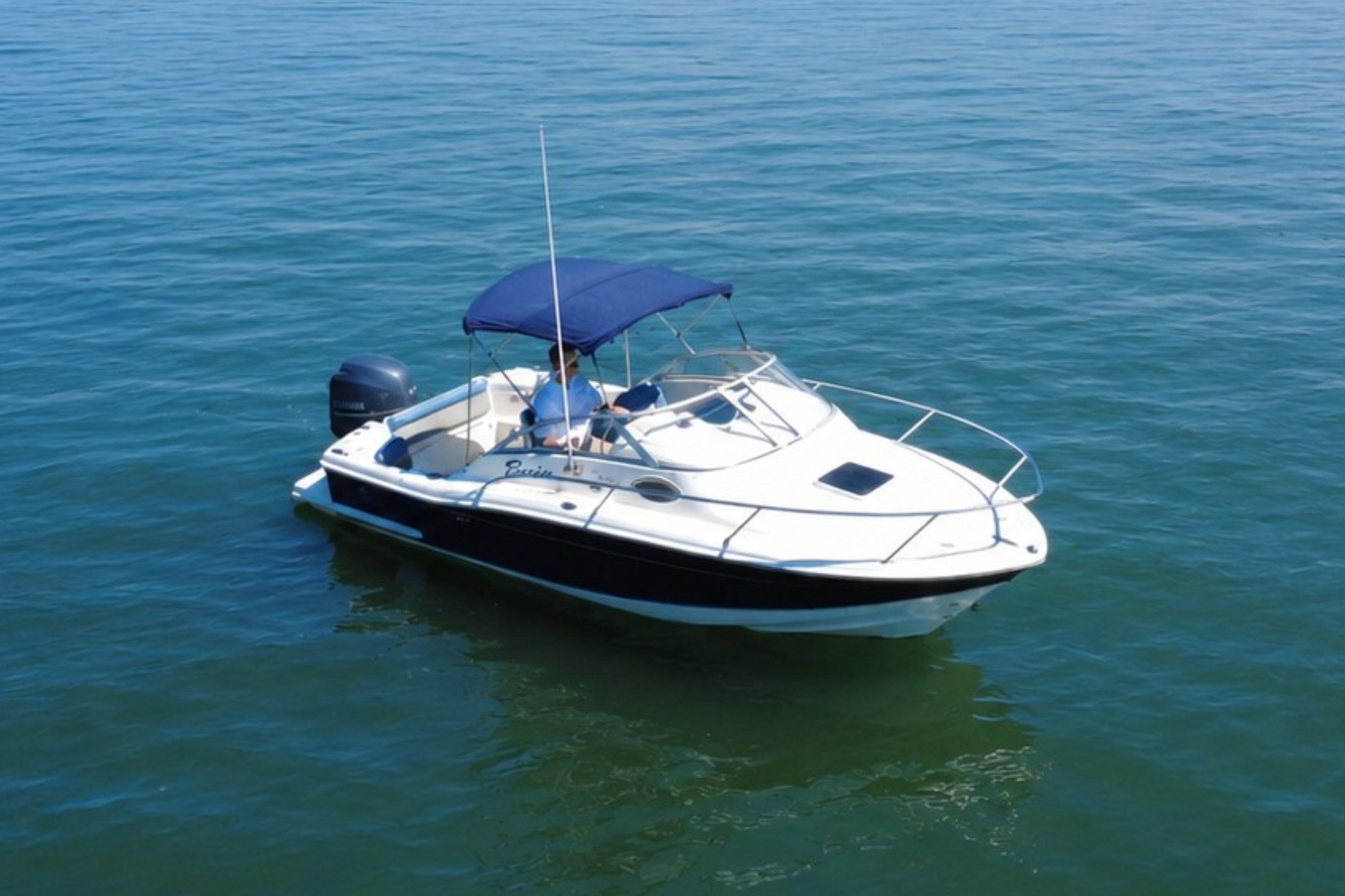 2008 Scout 222 Abaco boat with blue canopy on calm water.