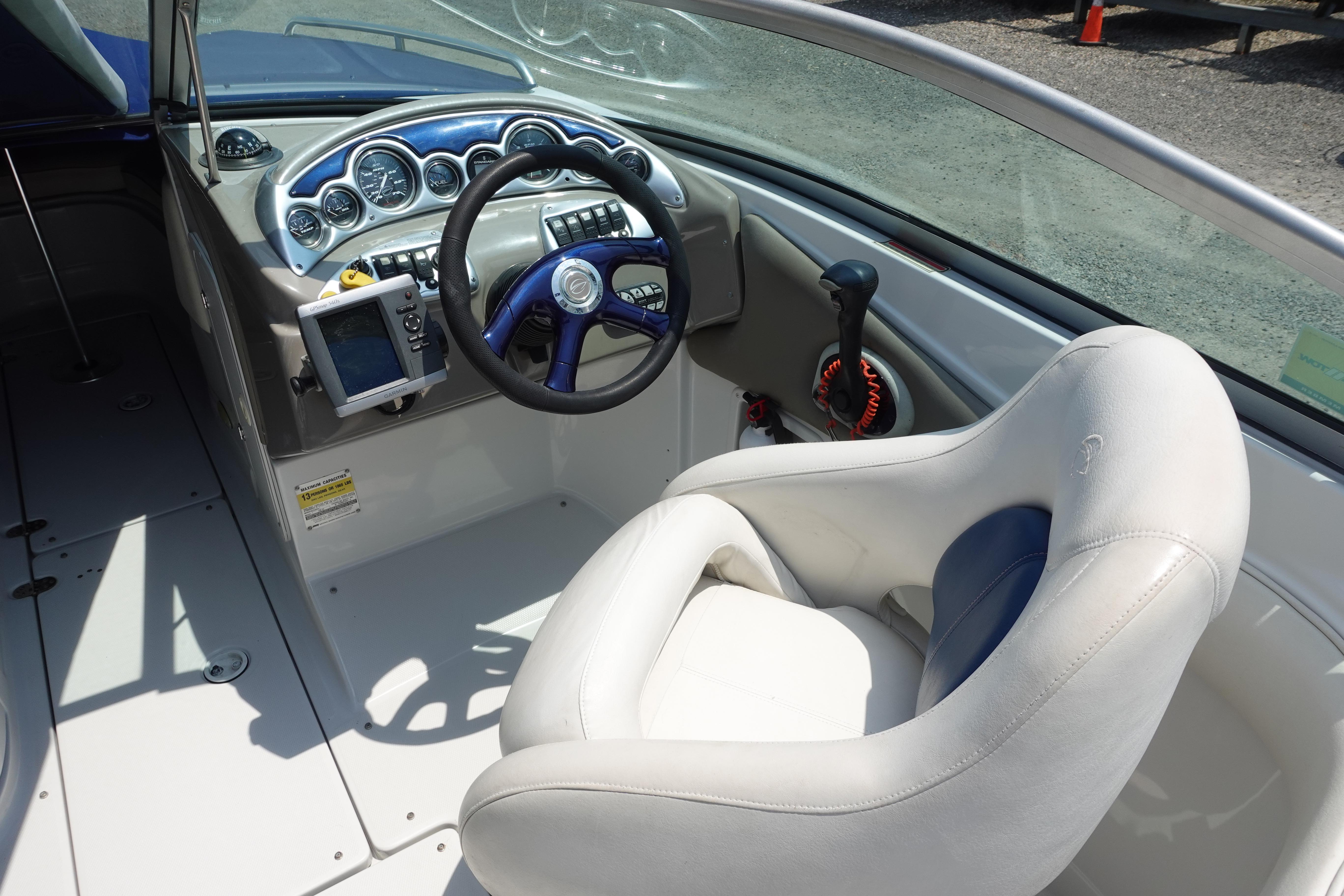 Interior of a 2004 Crownline 240 EX boat showing steering wheel and dashboard controls.