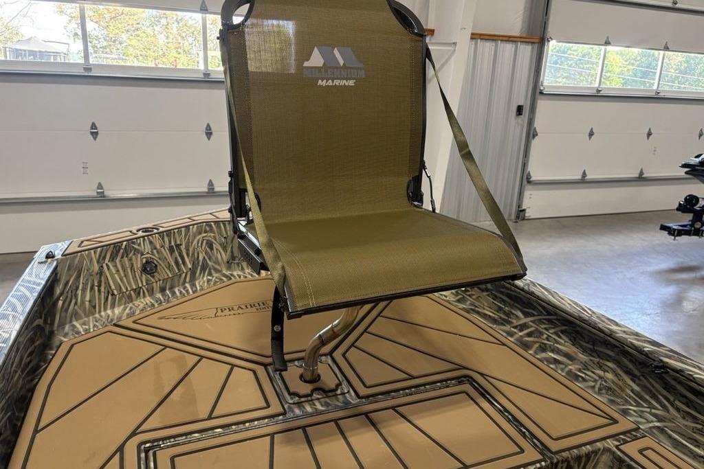 2026 Tracker Grizzly 1650 T Prairie Wings Edition boat with camo seating in a garage.