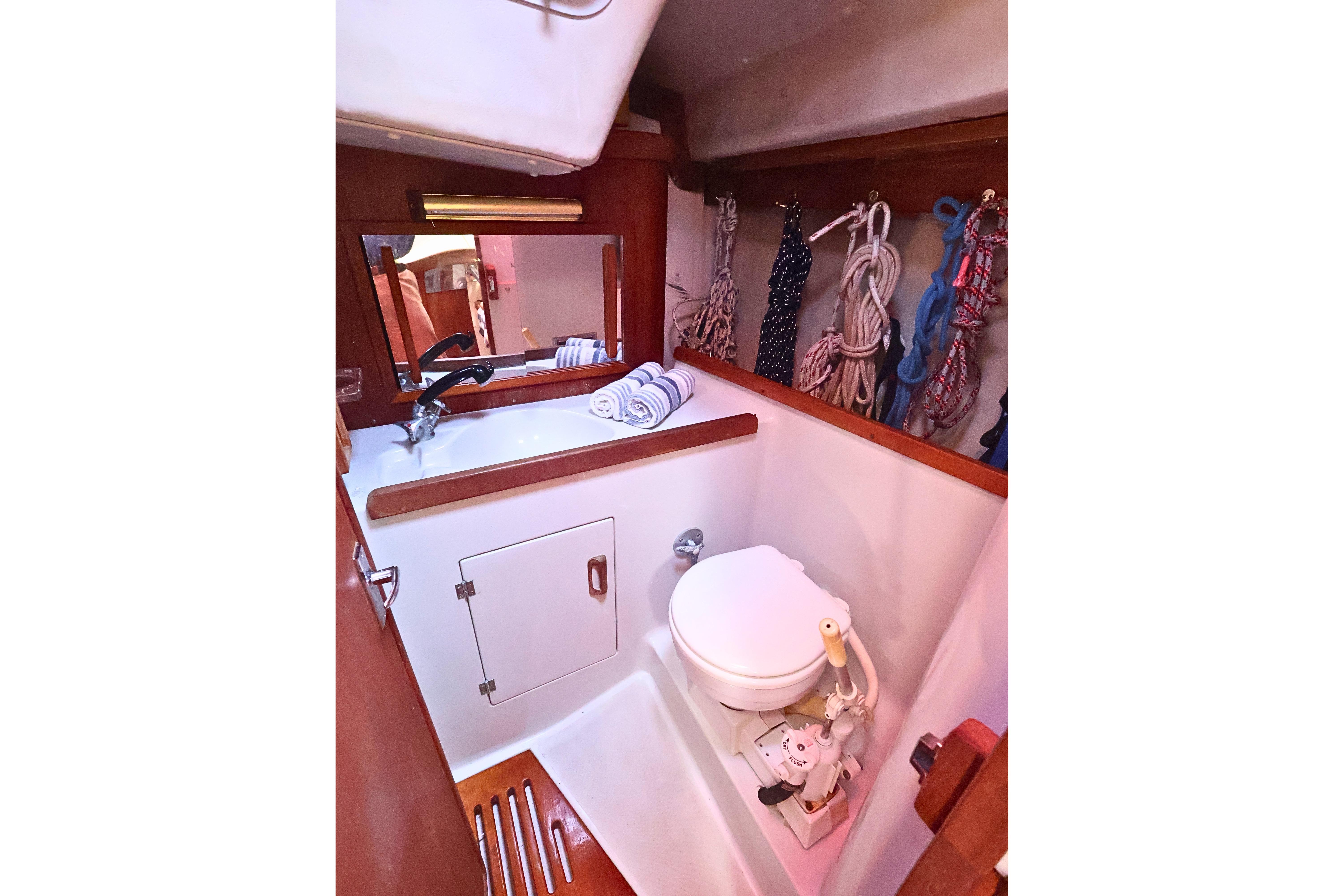 1989 J Boat J 40 yacht bathroom with sink, mirror, and marine toilet.